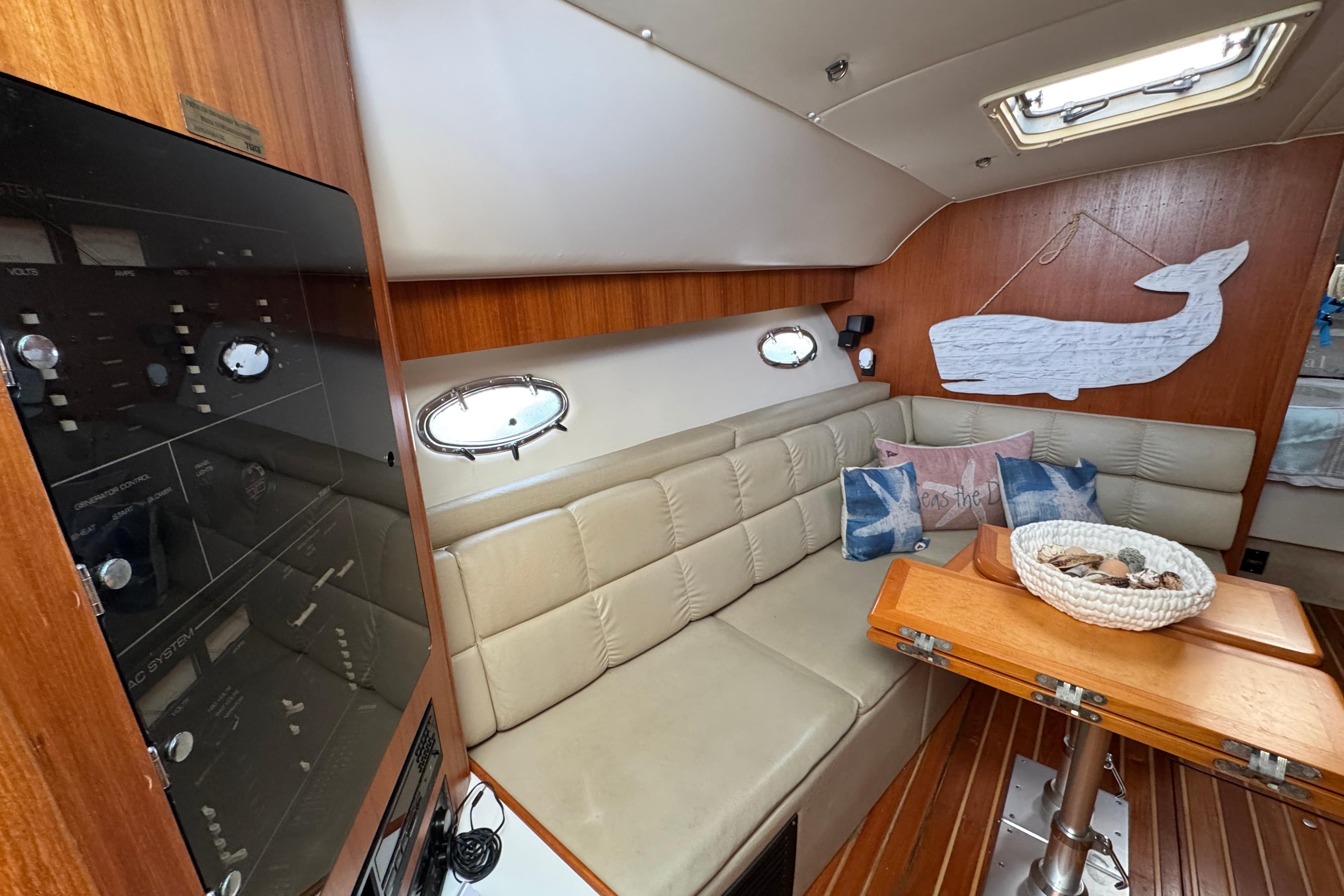 1998 Tiara Yachts 4100 Open interior with beige seating, wooden table, and nautical decor.