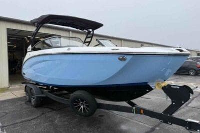 2026 Yamaha Boats 252SD in light blue on trailer, parked outside a building.