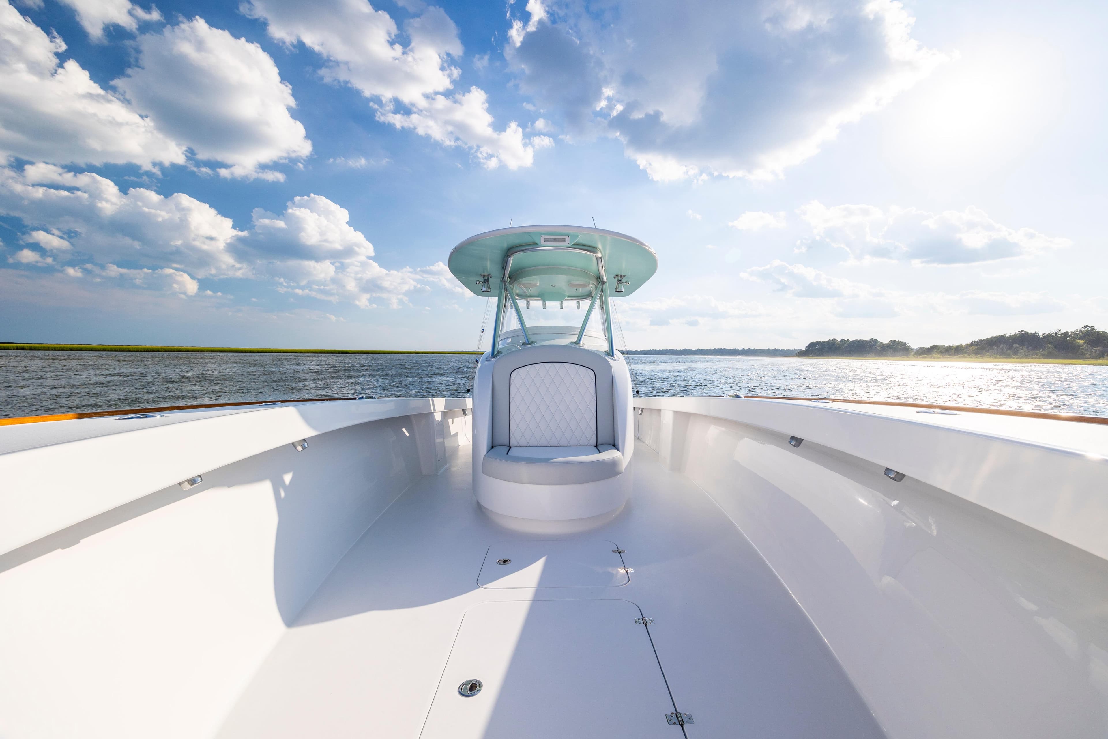 2018 Tribute 37 boat on open water under a bright, cloudy sky.