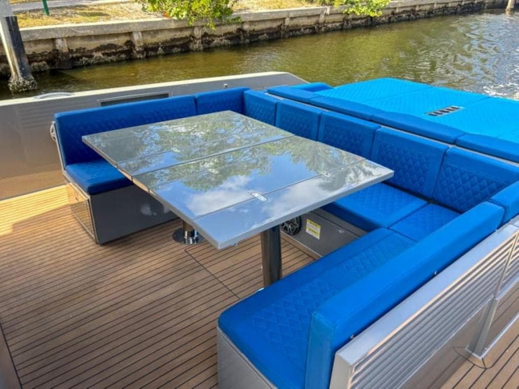 De Antonio Yachts D42 Open 2023 model with blue seating and a sleek dining table.