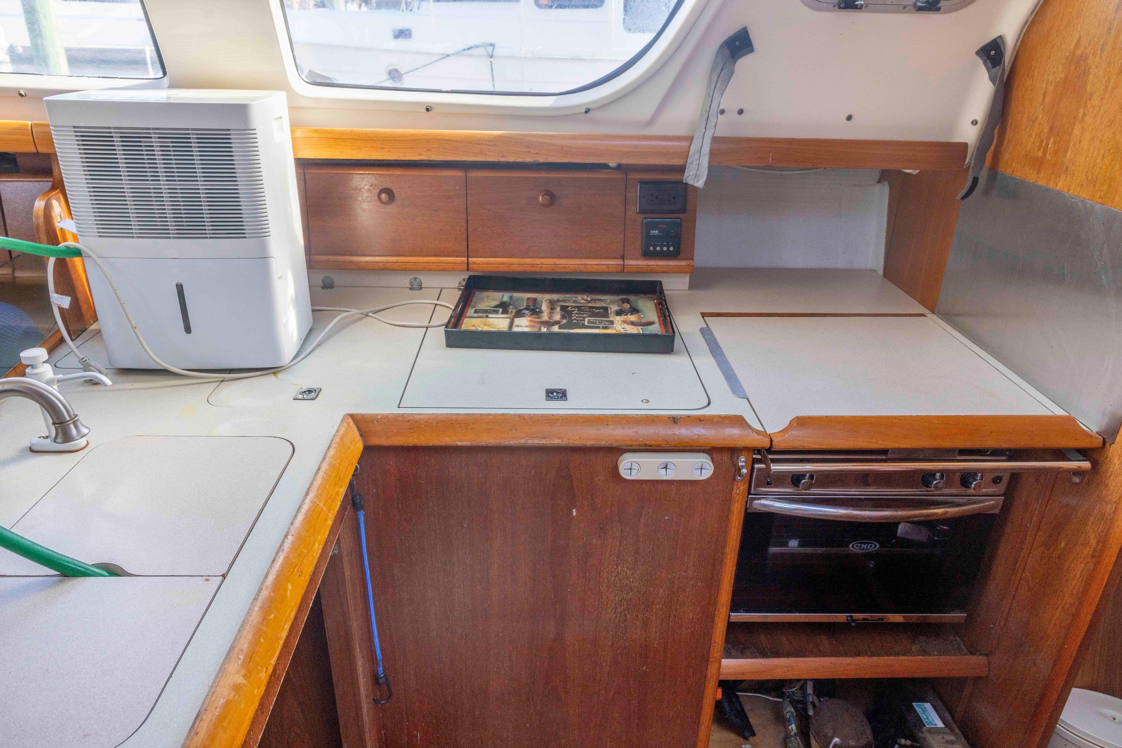 Interior of 2001 Jeanneau Sun Odyssey 43 DS yacht kitchen with appliances and wooden cabinetry.