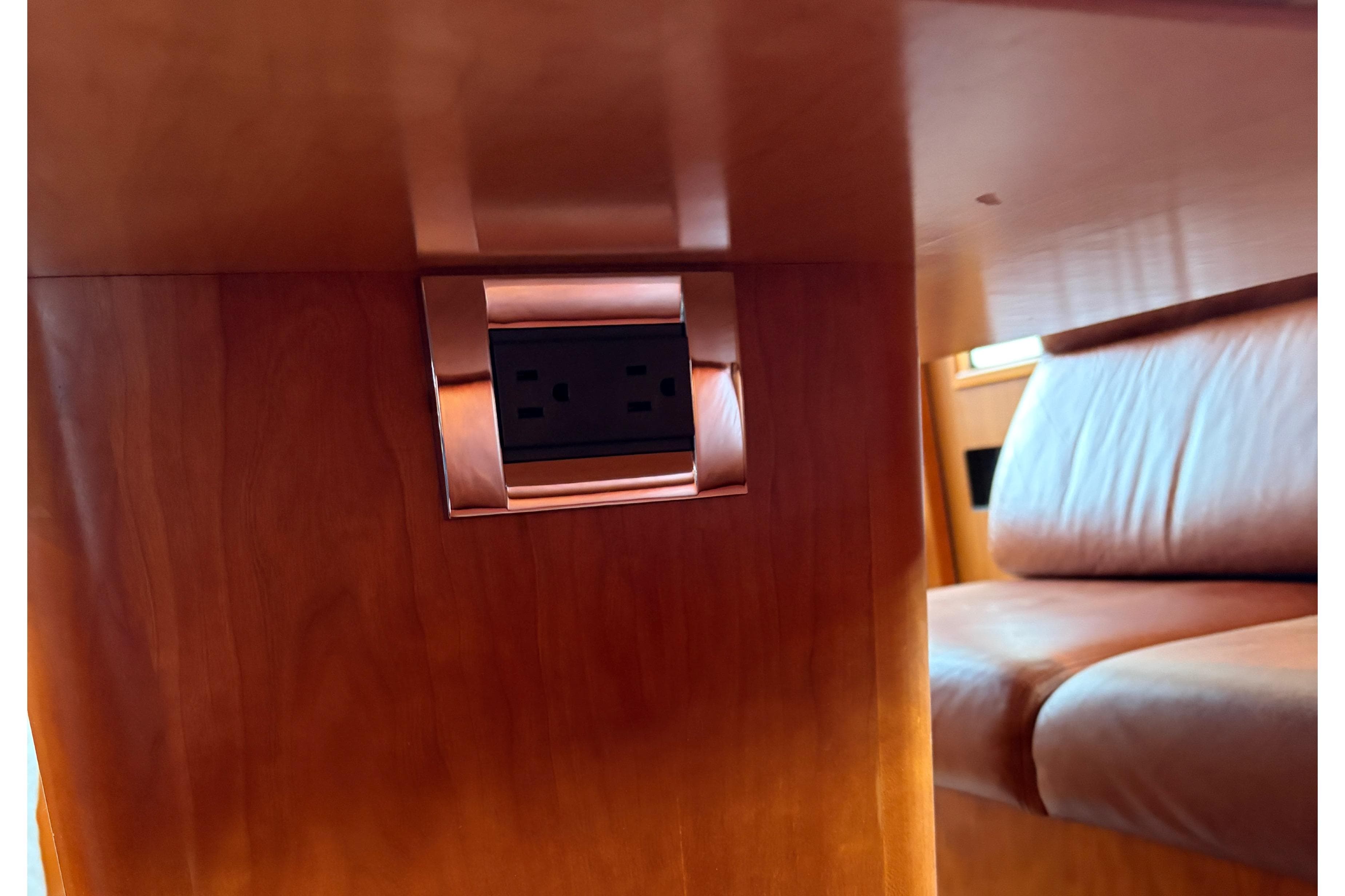 Power outlet on wooden panel inside 2001 West Bay 58 RPH yacht interior.