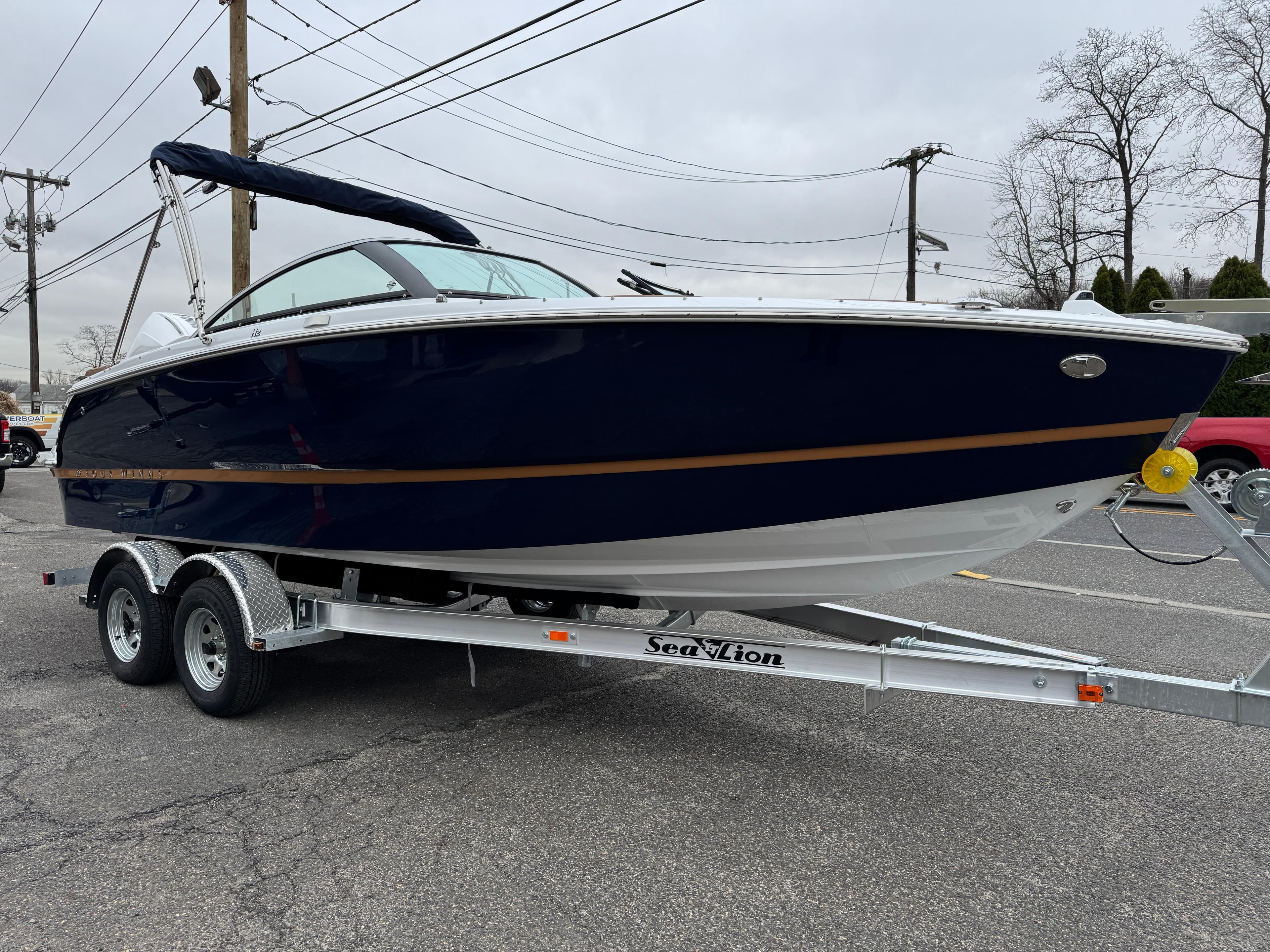2025 Four Winns H2 OB boat on trailer, parked outdoors.