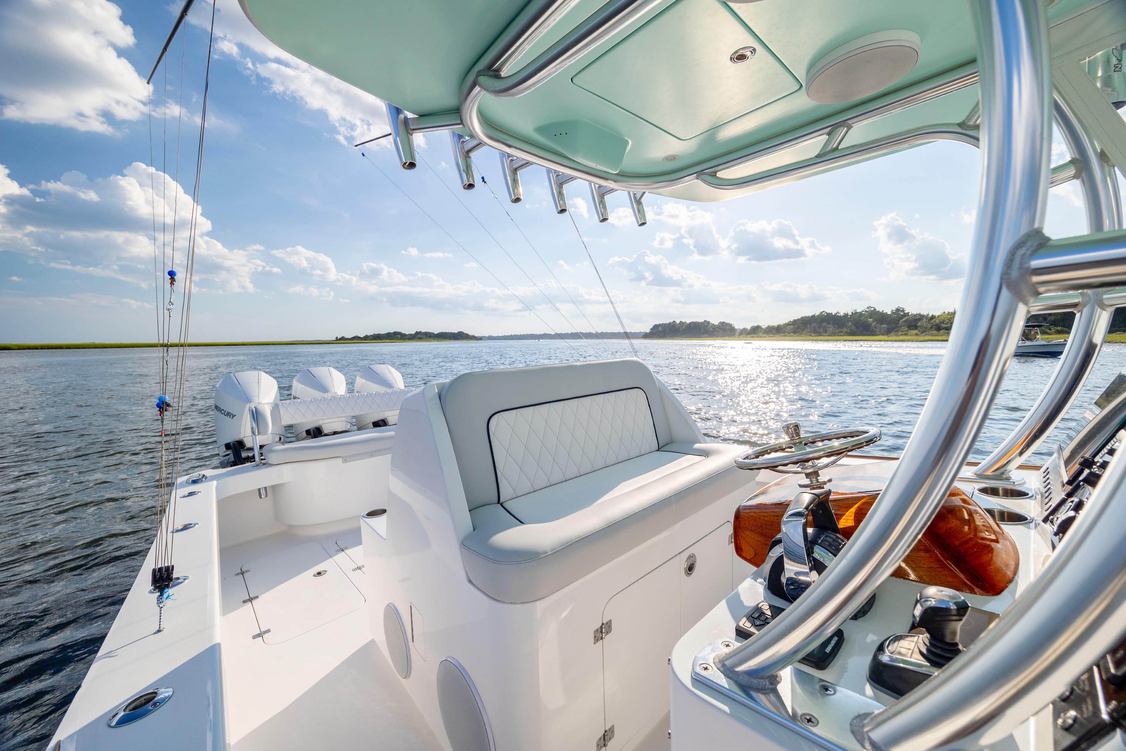 2018 Tribute 37 boat interior with helm, ocean view, and clear sky.