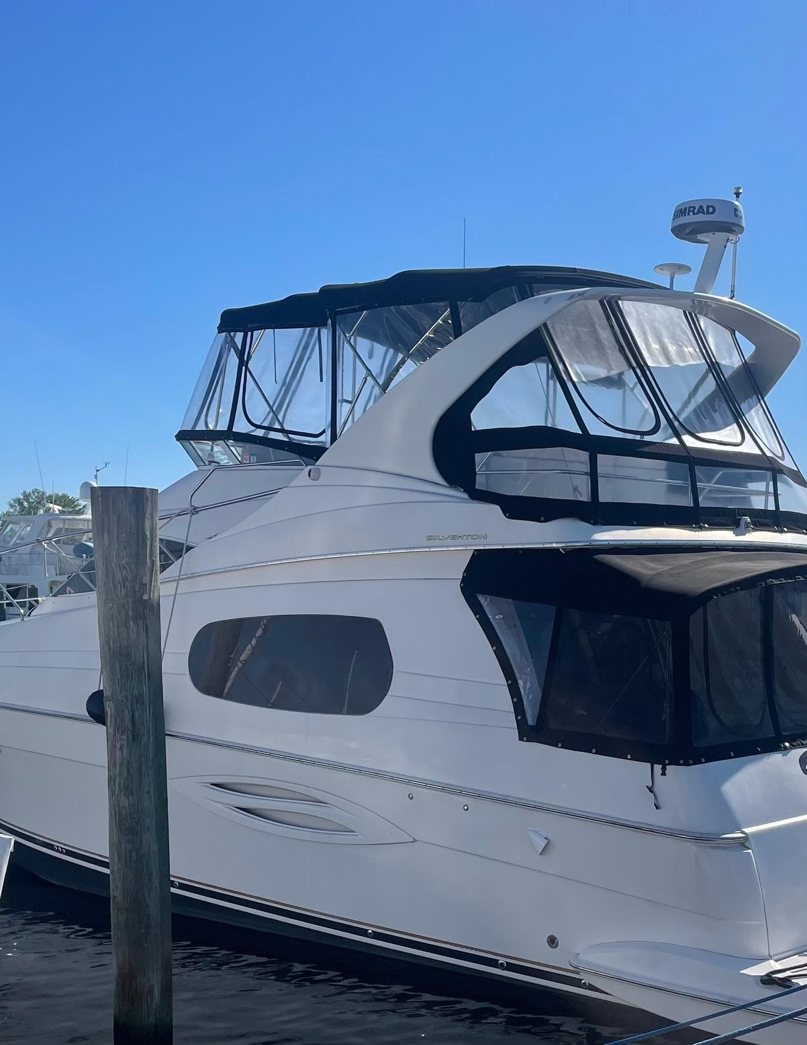 2003 Silverton 410 Sport Bridge yacht docked under clear blue sky.