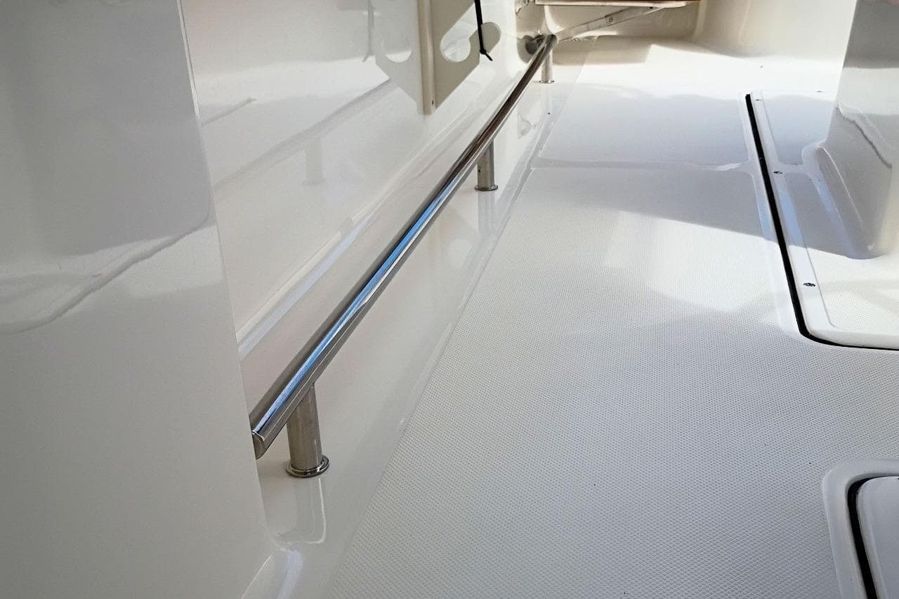2027 Pioneer 222 Sportfish boat interior with sleek stainless steel railing and textured flooring.