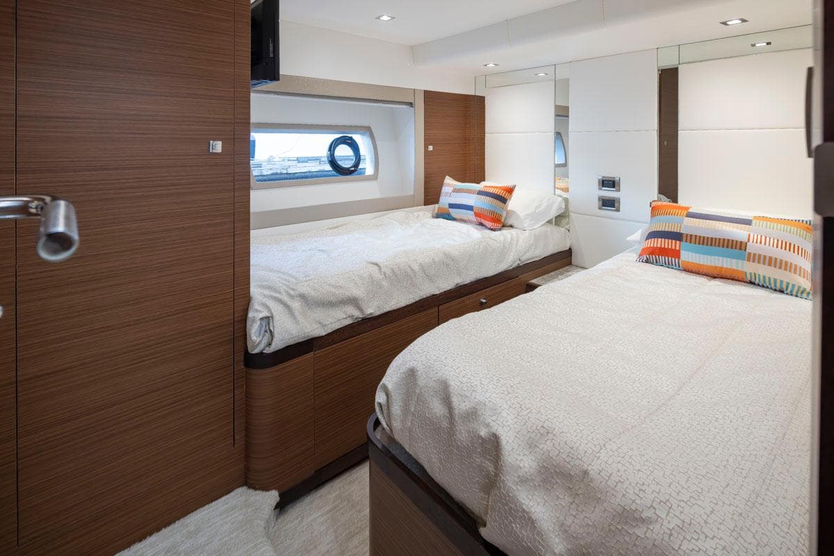 Luxurious cabin interior of 2017 Ocean Alexander 70e yacht with twin beds and colorful pillows.