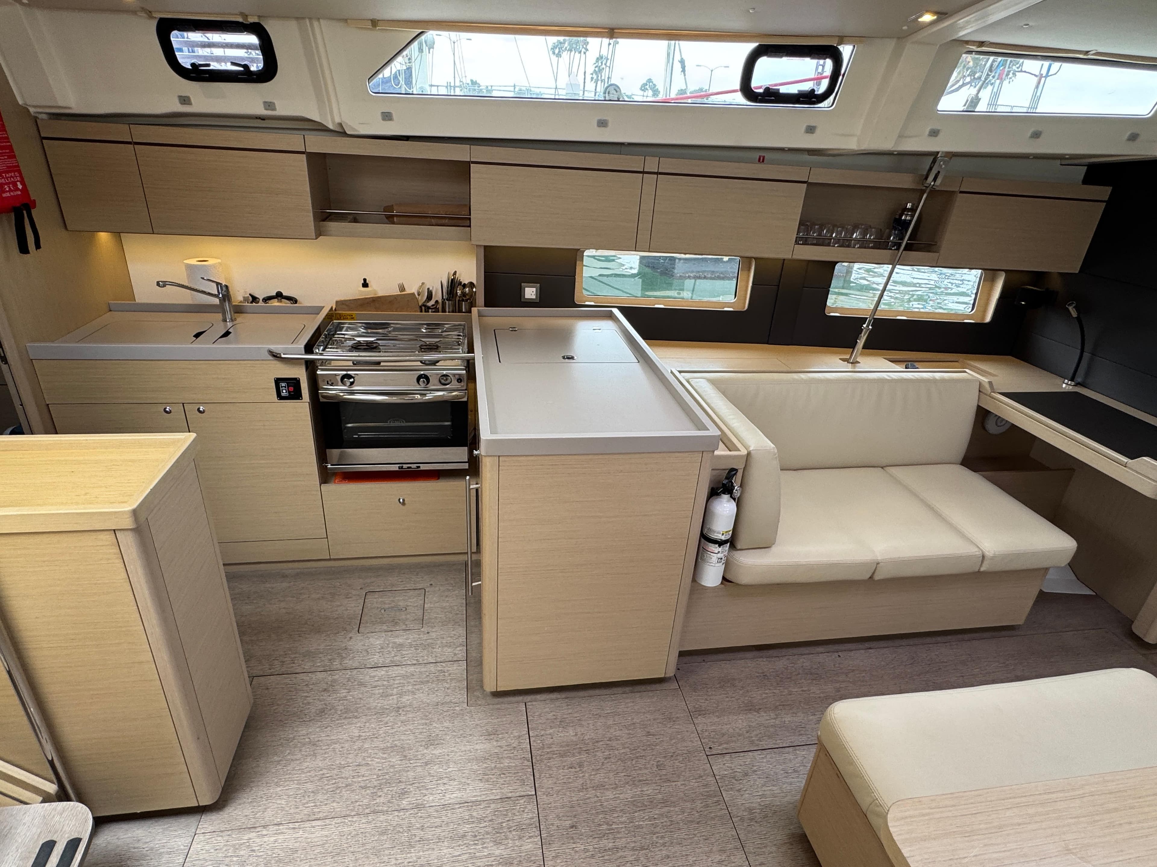 Modern interior of 2021 Beneteau Oceanis 46.1 yacht, featuring a sleek kitchen and seating area.