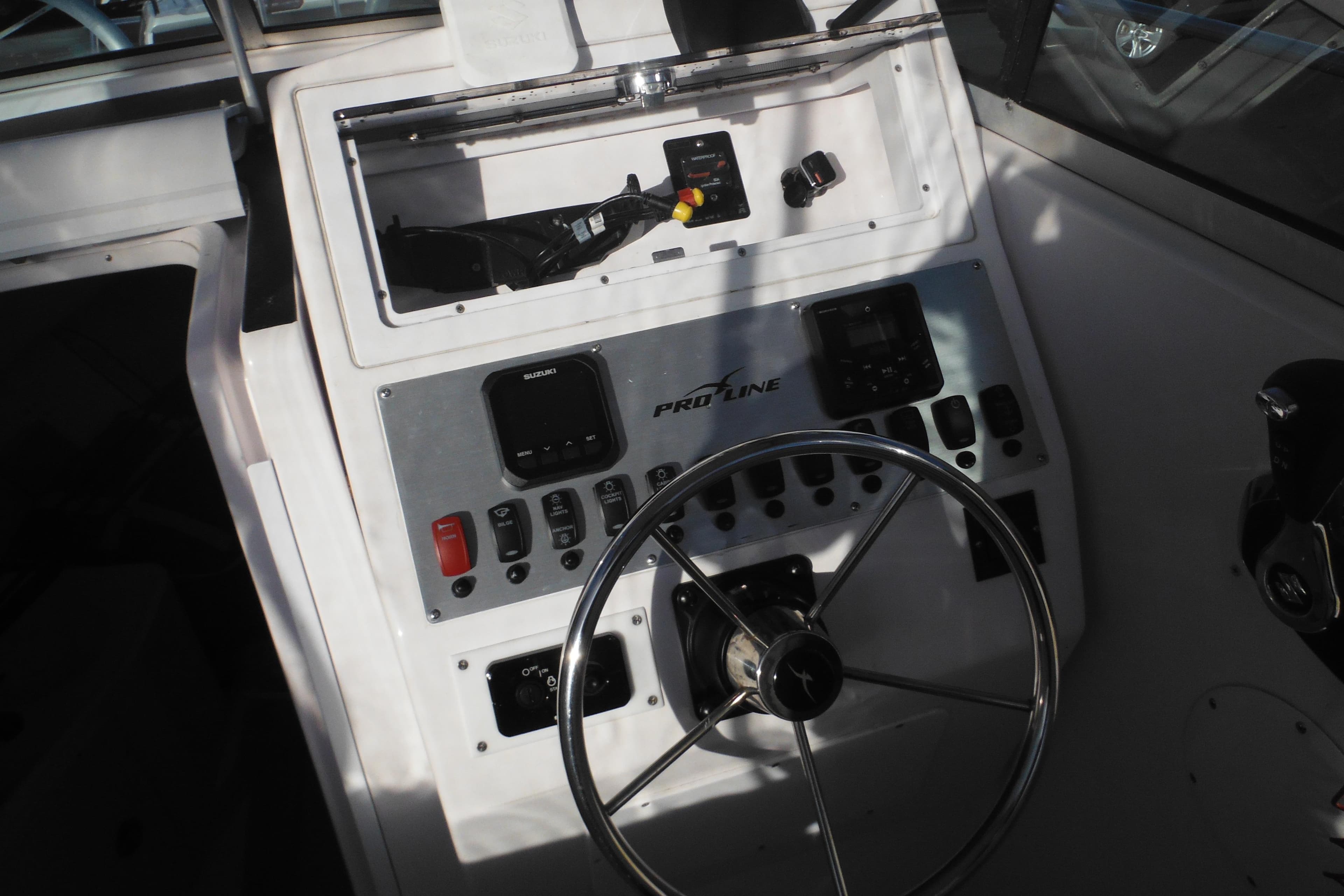 Steering console of a 2000 Pro-Line 23 Walkaround boat with controls and gauges.