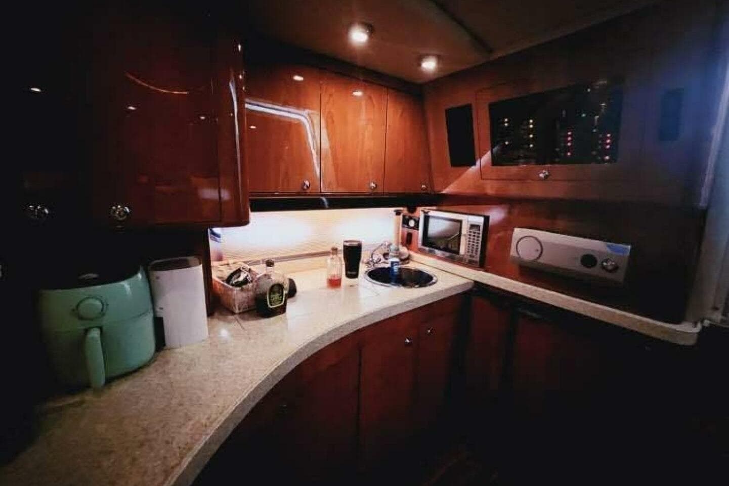 2007 Regal Commodore 4460 yacht kitchen with wooden cabinets and modern appliances.