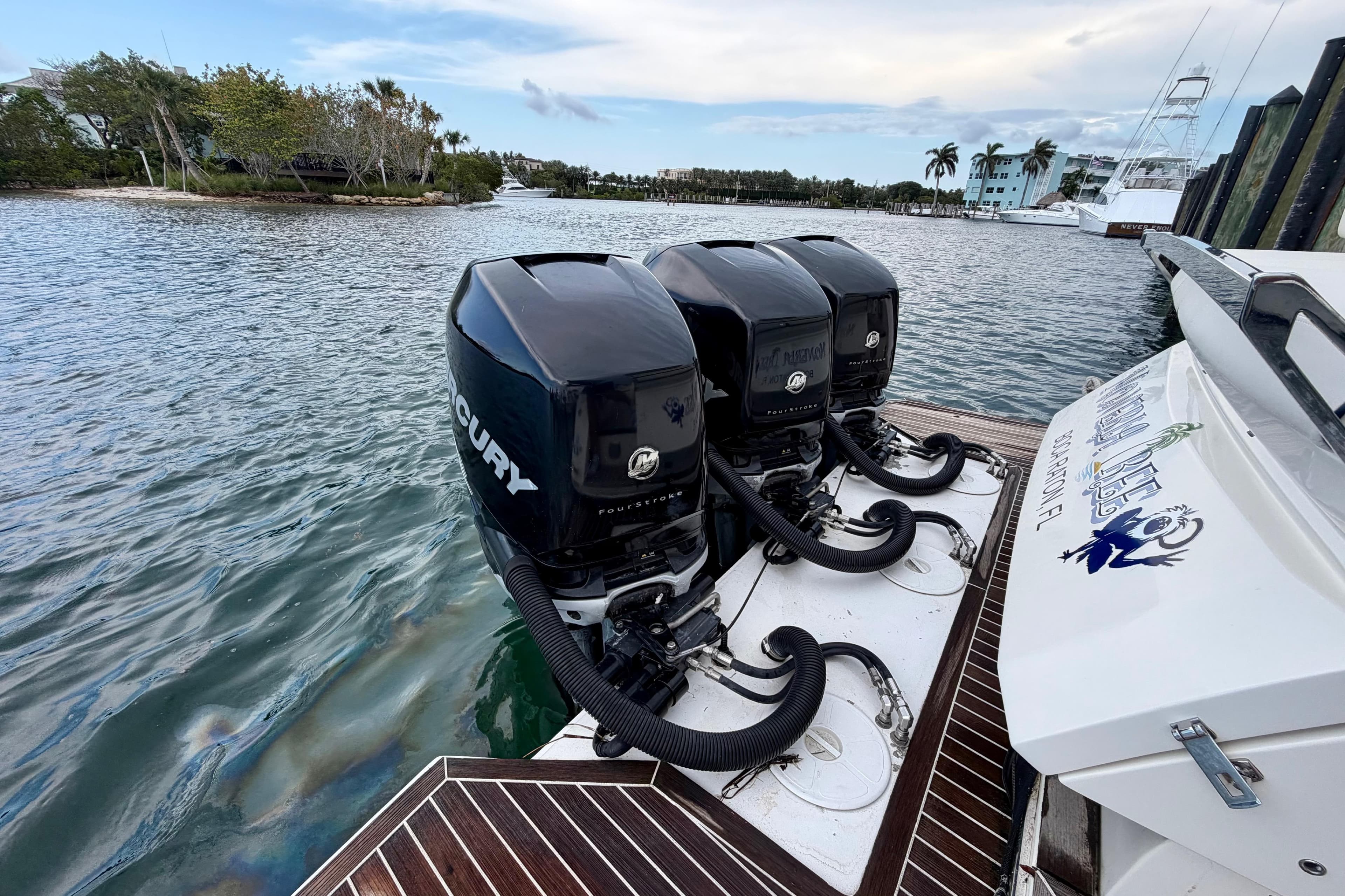 Azimut Verve 40 boat with triple Mercury outboard engines, docked by scenic waterfront.