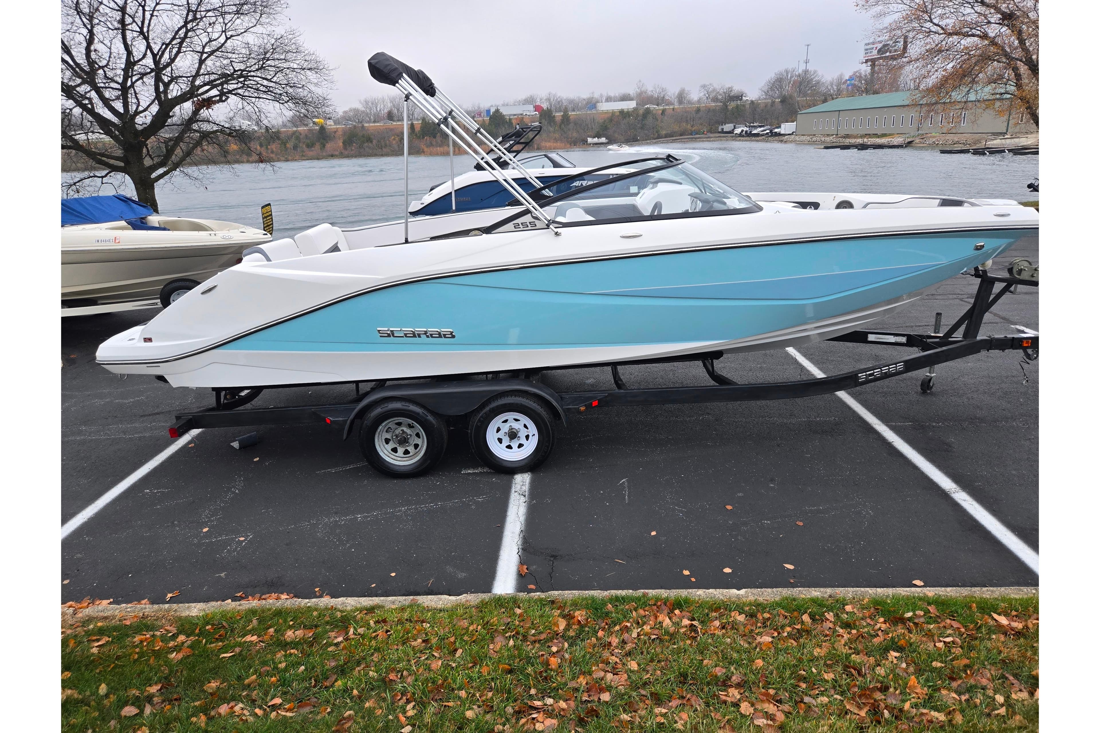 2021 Scarab 255 ID boat on trailer, parked near a lake, showcasing sleek design.
