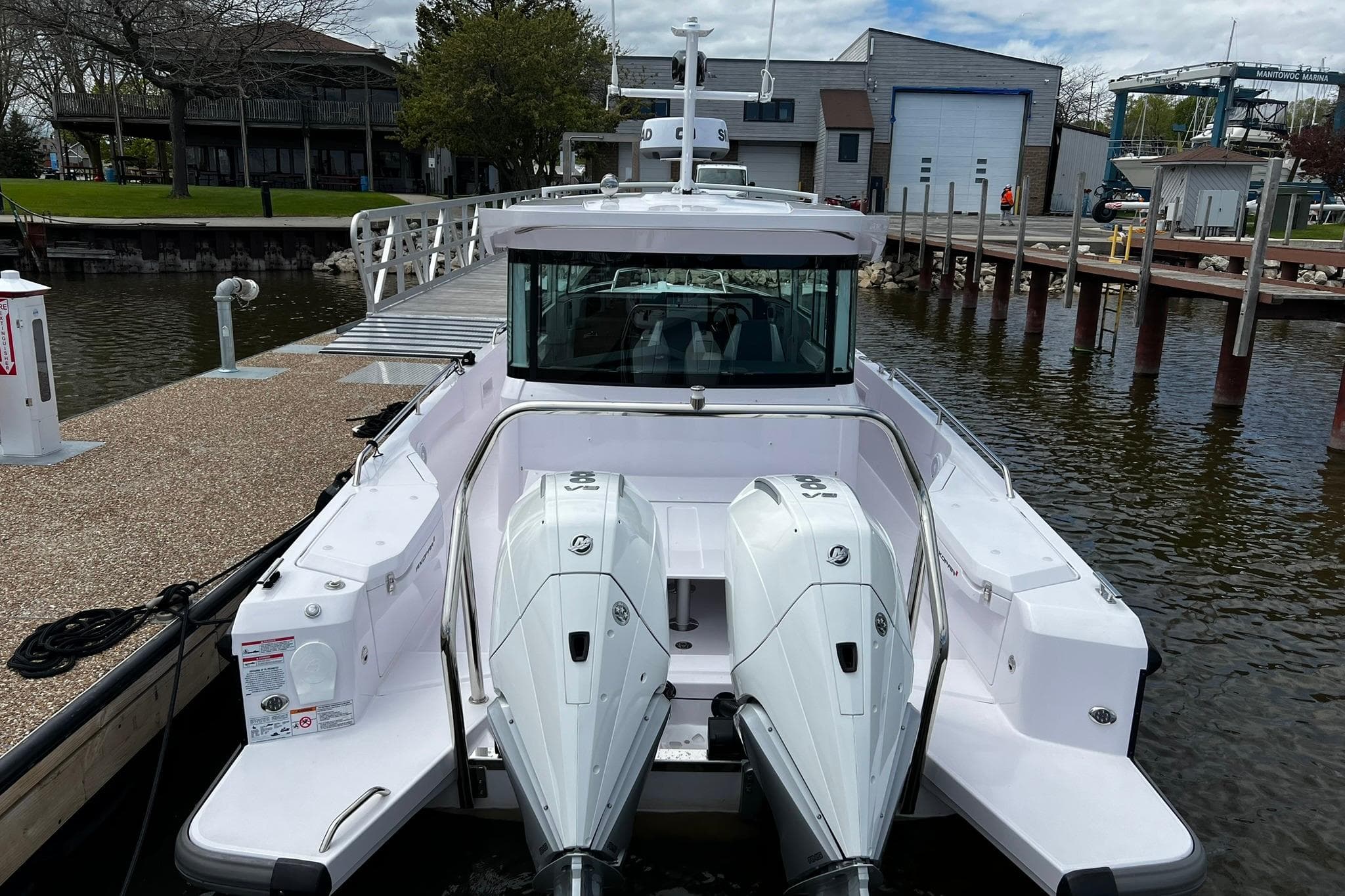 2024 Axopar 45 XC Cross Cabin boat docked at marina with twin engines.