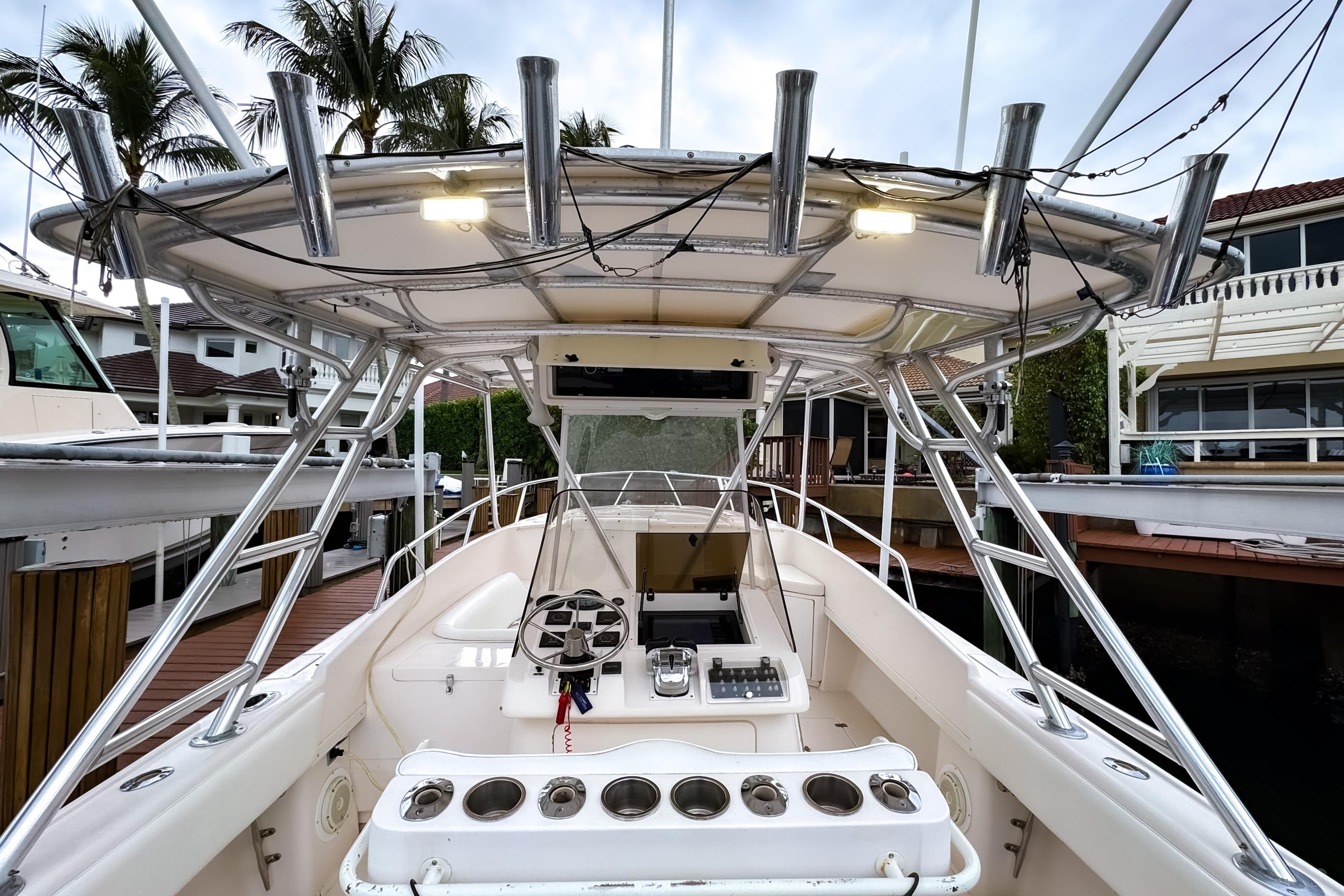 1998 Intrepid 356 Cuddy boat interior with helm, rod holders, and docked setting.