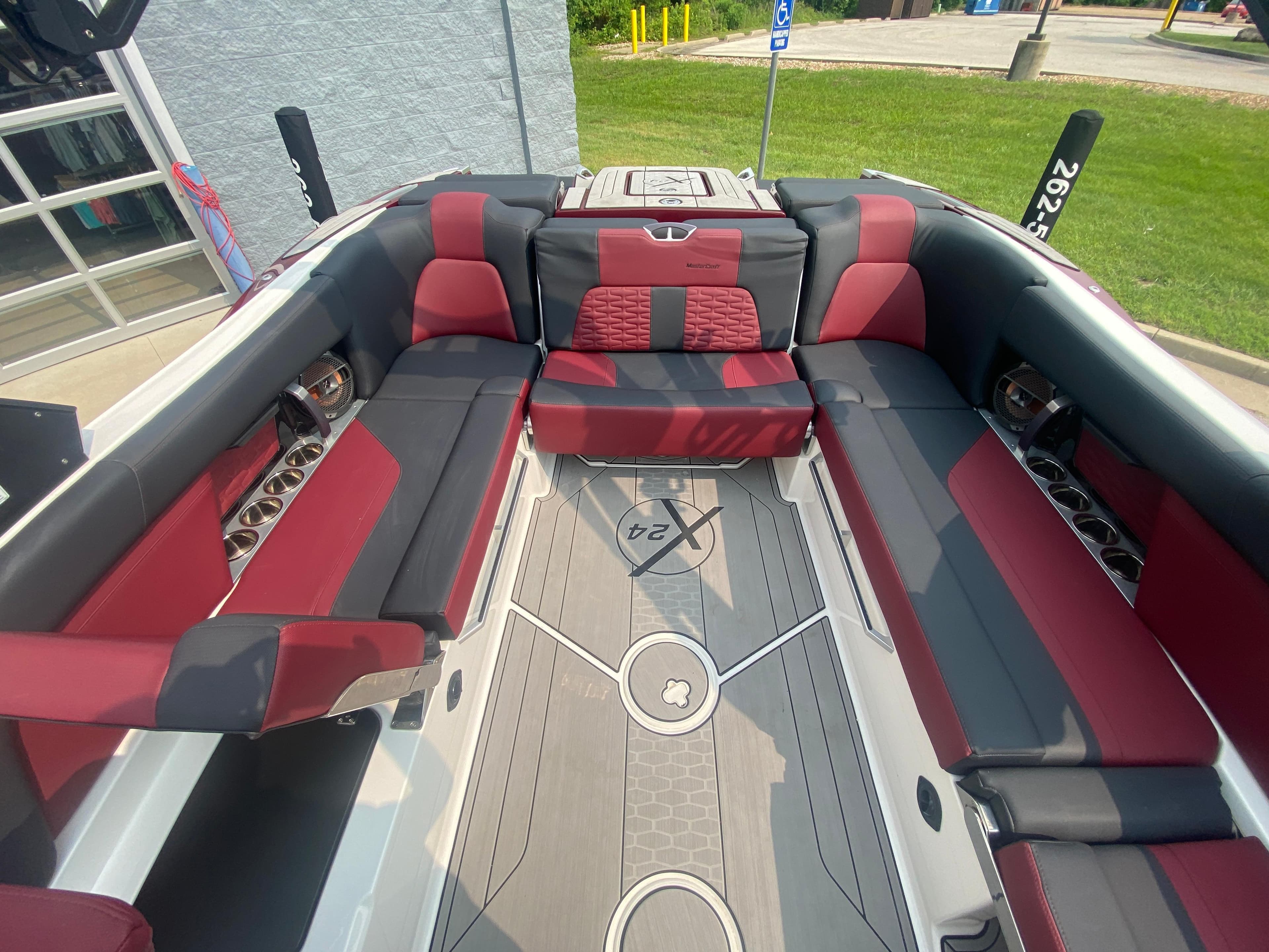 2022 MasterCraft X24 boat interior with red and black seating, modern design, and spacious layout.