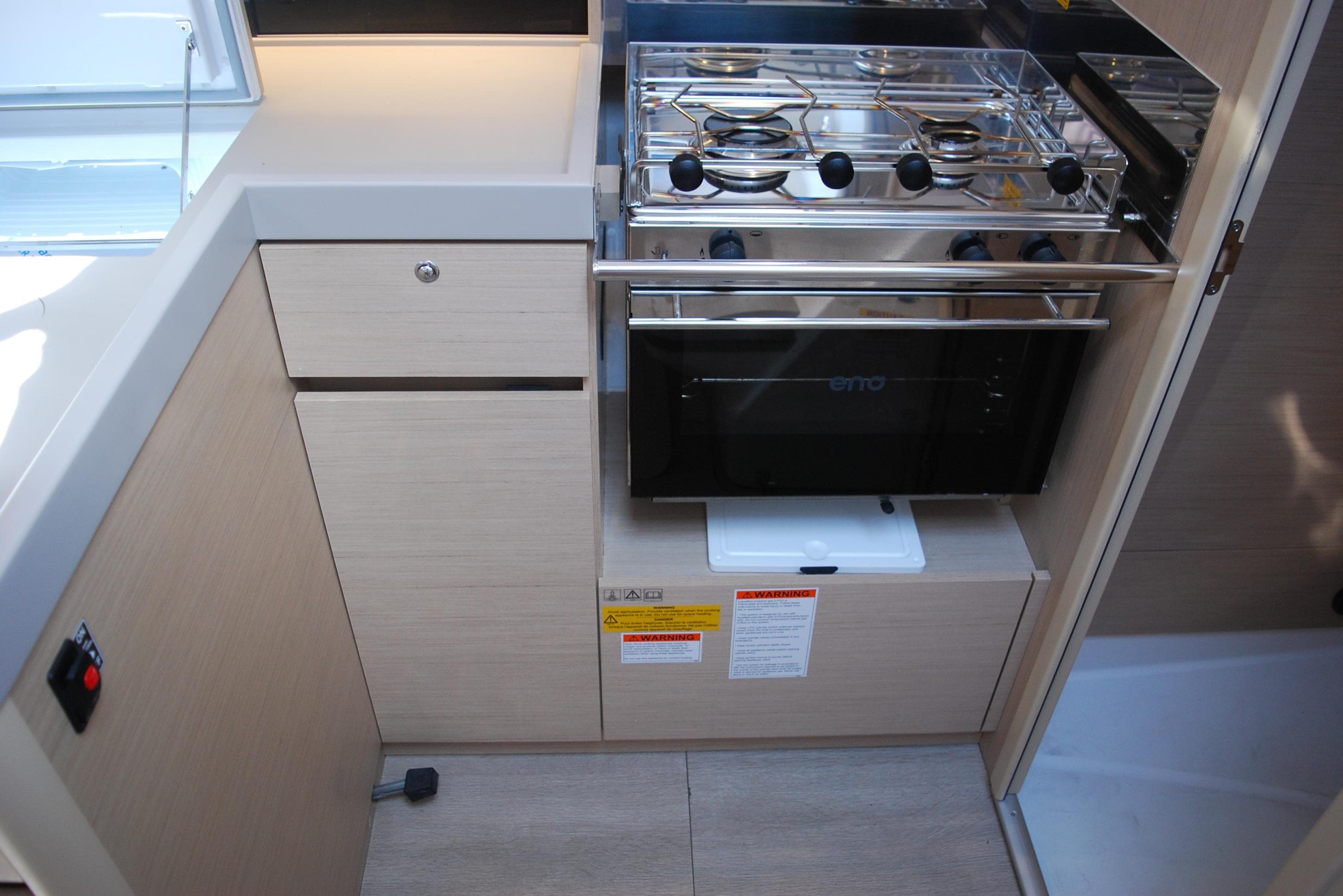 Modern kitchen area in 2023 Beneteau Oceanis 34.1 yacht with stove and cabinetry.