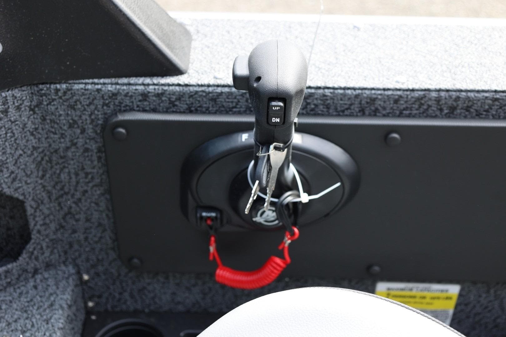 Control panel of 2026 Lund 1875 Impact XS Sport boat with throttle and key.