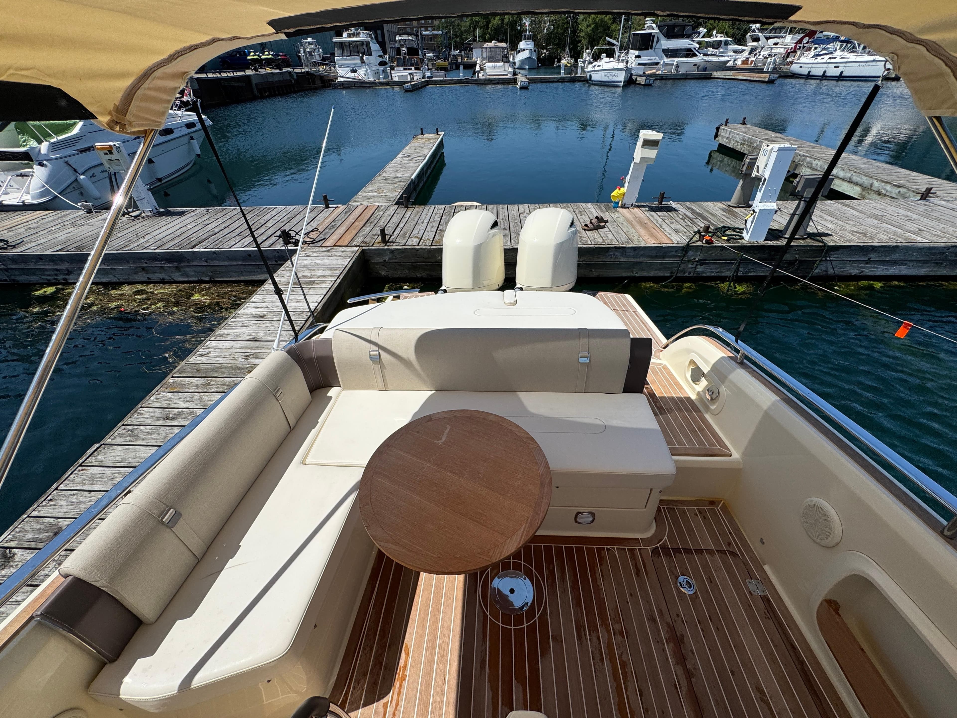 2023 Invictus GT 280S yacht with elegant seating and wooden deck at marina.