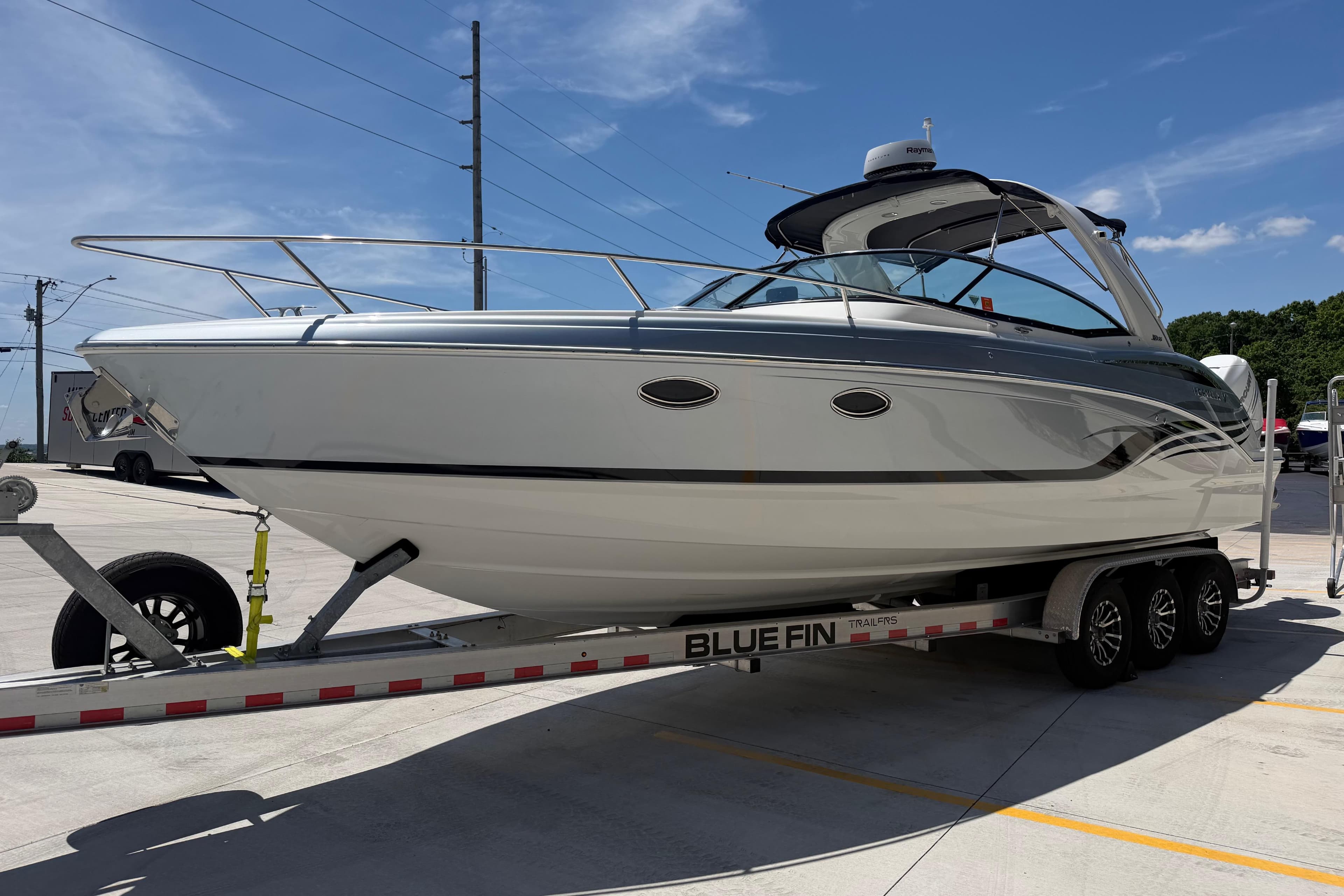 2022 Formula 310 Sun Sport boat on trailer under clear blue sky.