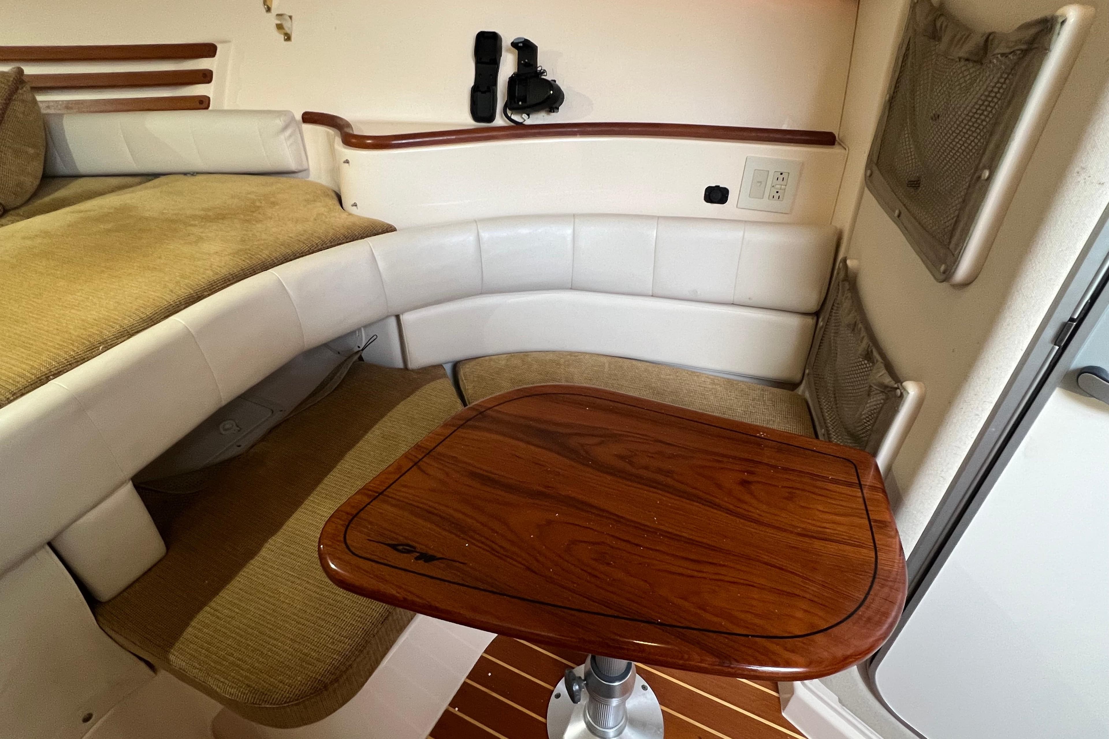 Interior of 2006 Grady-White Express 330 boat with seating and wooden table.
