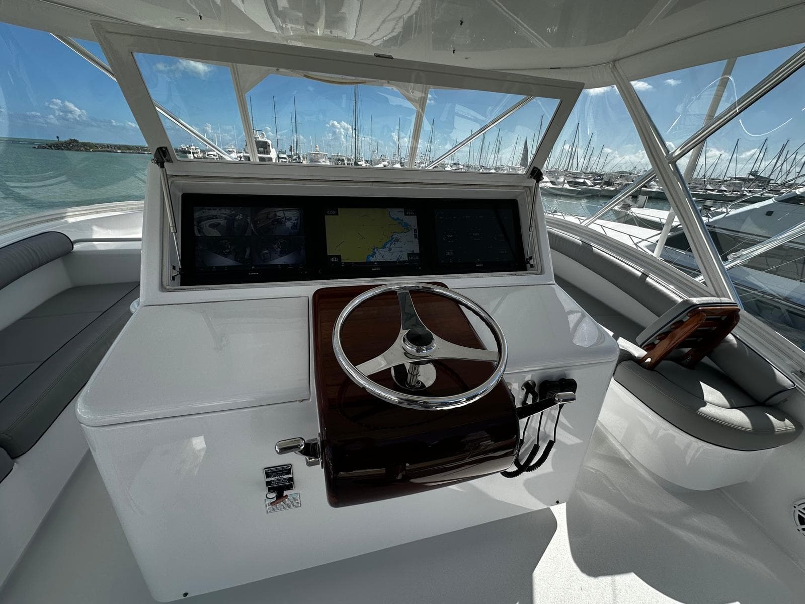 Helm of 2011 Hatteras GT60 yacht with steering wheel and navigation screens.