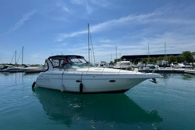 2000 Cruisers Yachts 3575 Express in marina, calm water, clear sky.