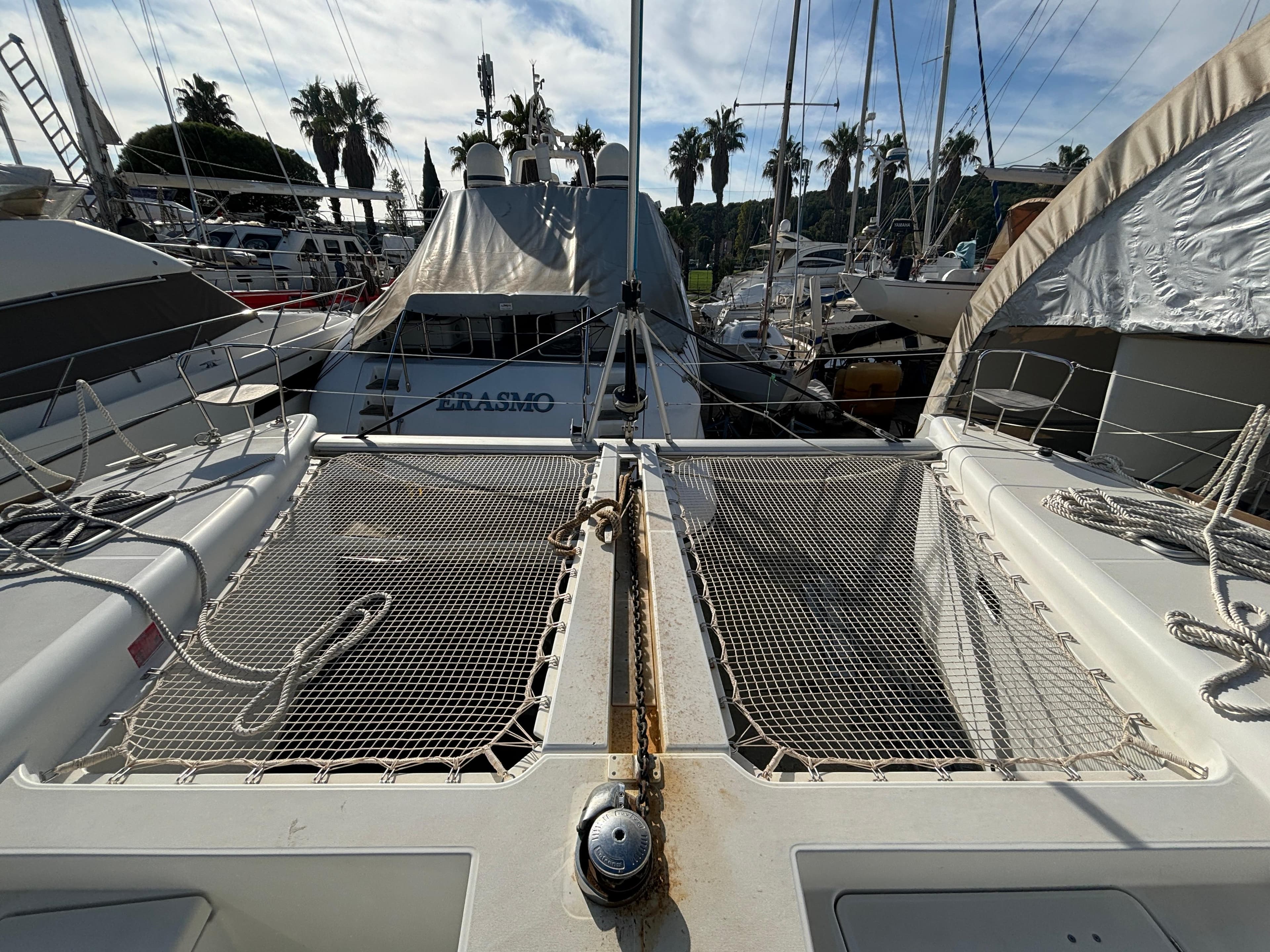 2019 Lagoon 450 F catamaran docked, featuring netted deck and marina background.