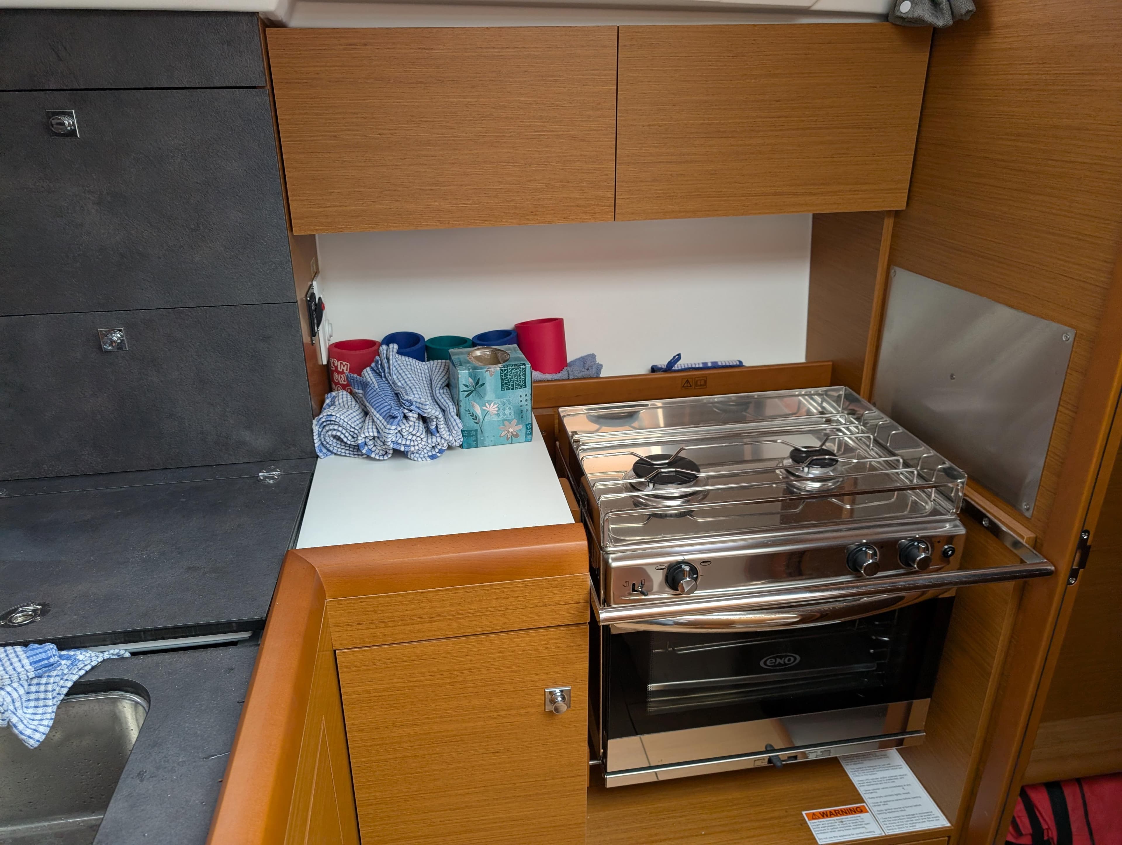 Modern kitchen in 2021 Jeanneau Sun Odyssey 349 yacht with stove and storage.