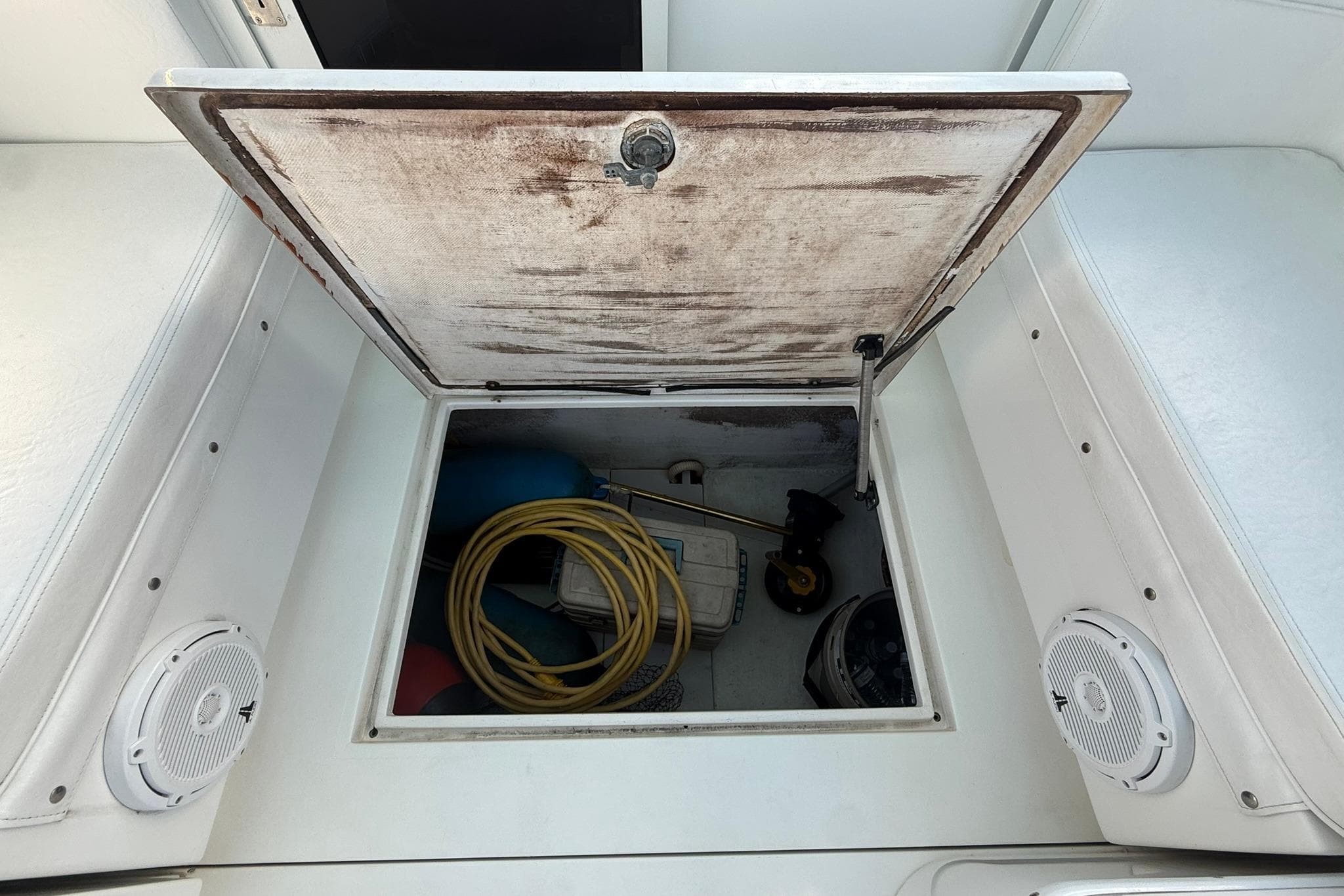 Open storage compartment on a 1998 Contender 35 Express boat, showing equipment and accessories.