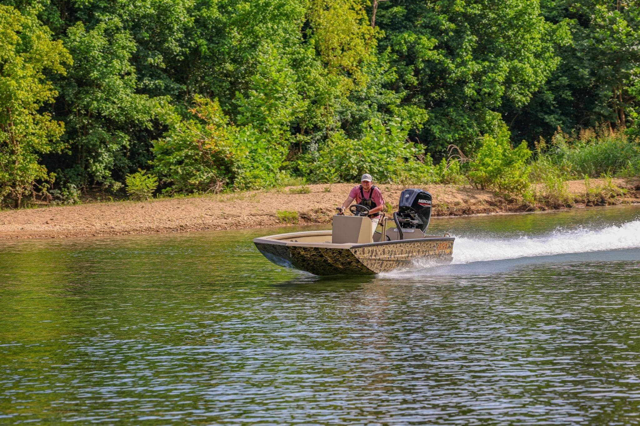 2026 Excel Switchblade boat speeding on a river, surrounded by lush greenery.