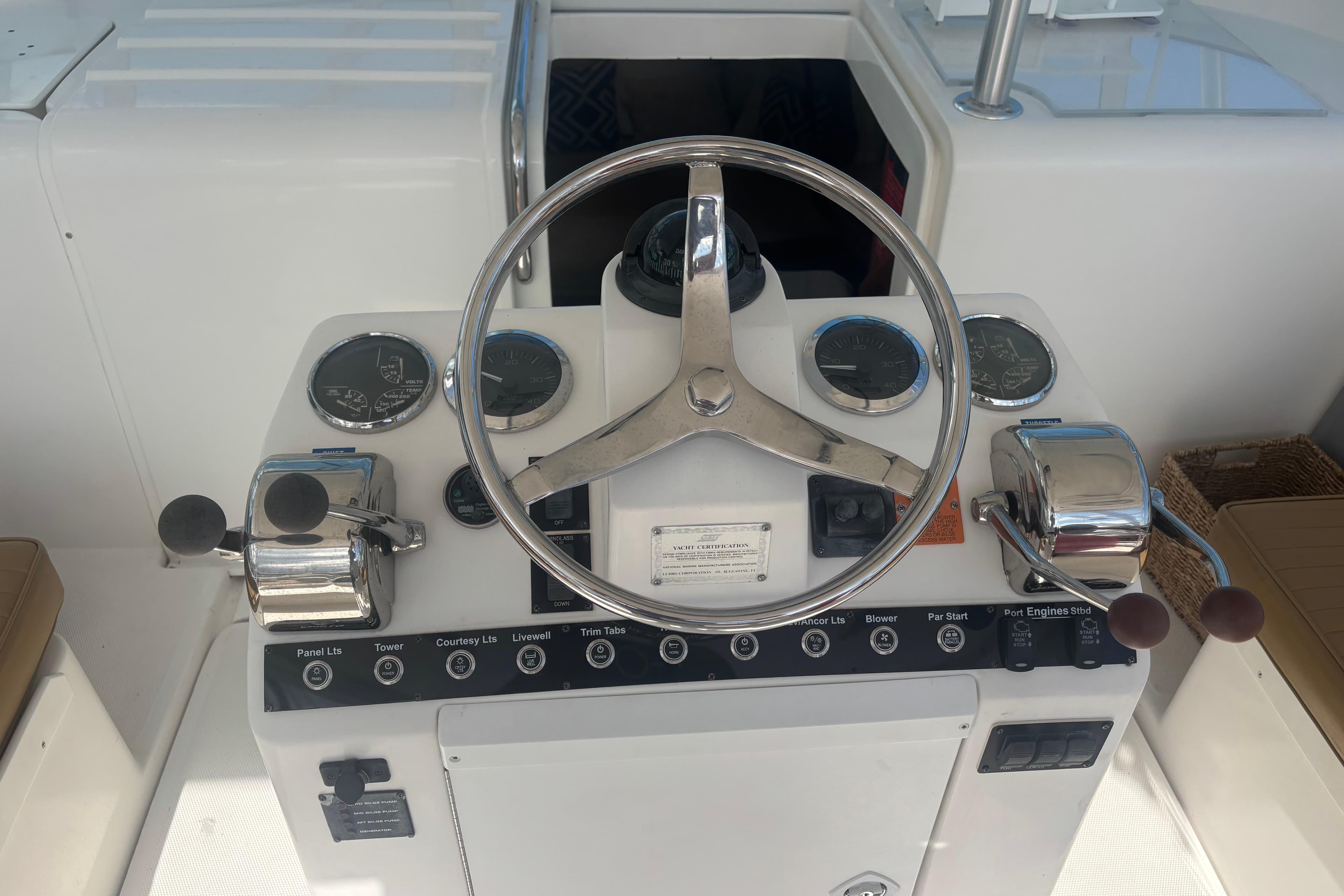 2004 Luhrs 32 Open helm with steering wheel, gauges, and controls.