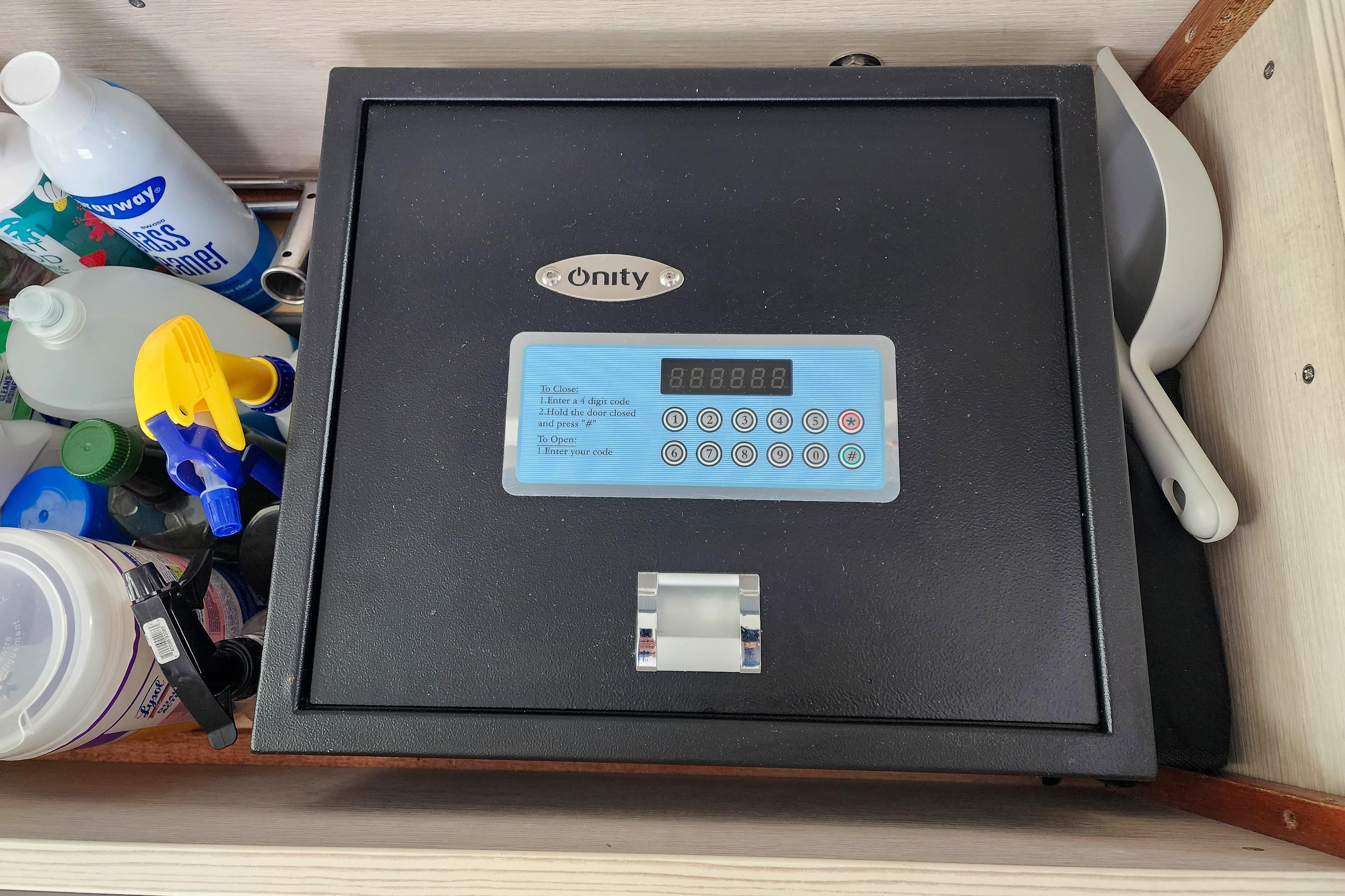 Secure safe with digital keypad, surrounded by cleaning supplies on Leopard 45, 2020 model.