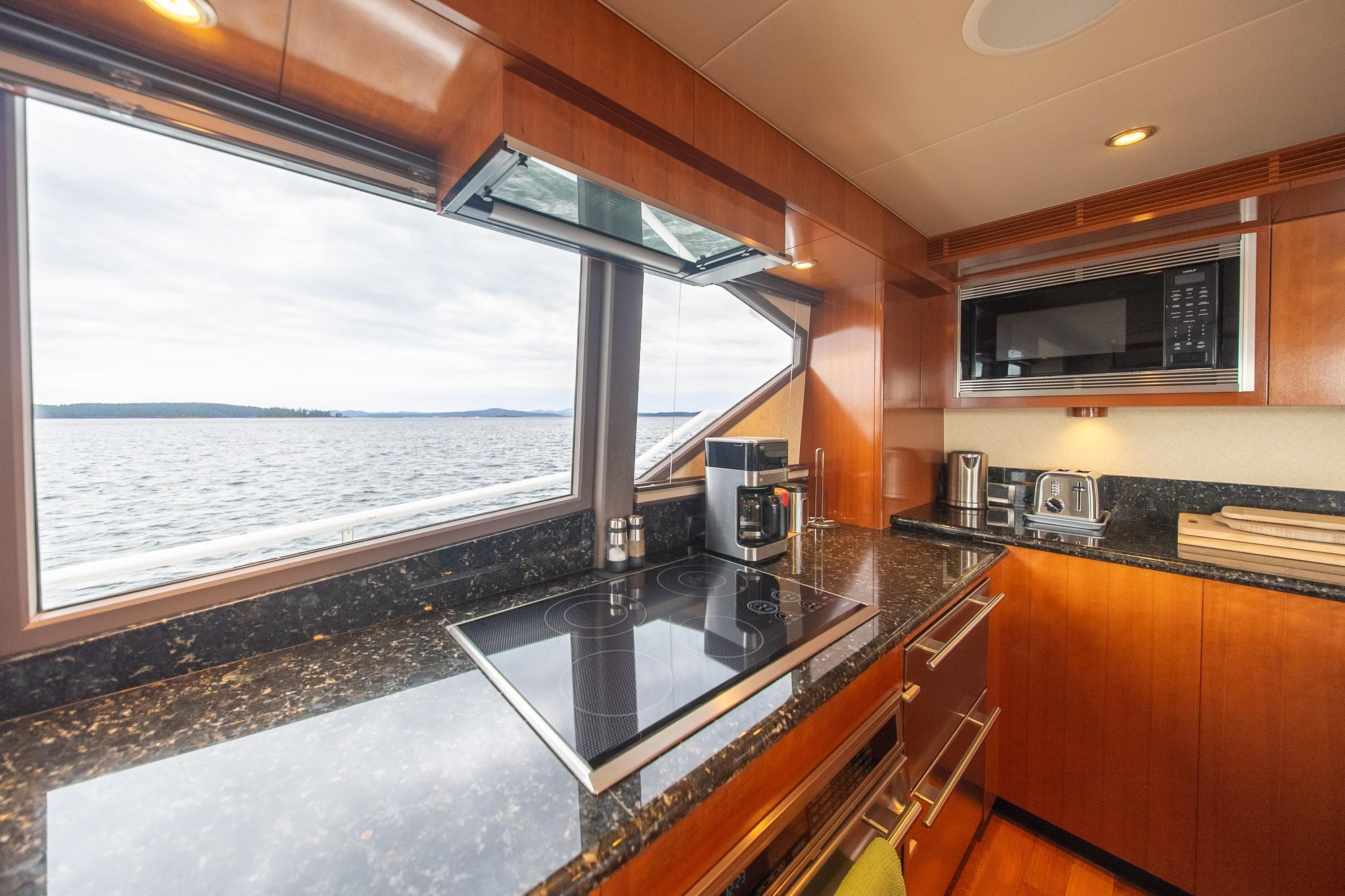 Luxurious kitchen interior of 2002 Striker 76 Sportfish Motor Yacht with ocean view.
