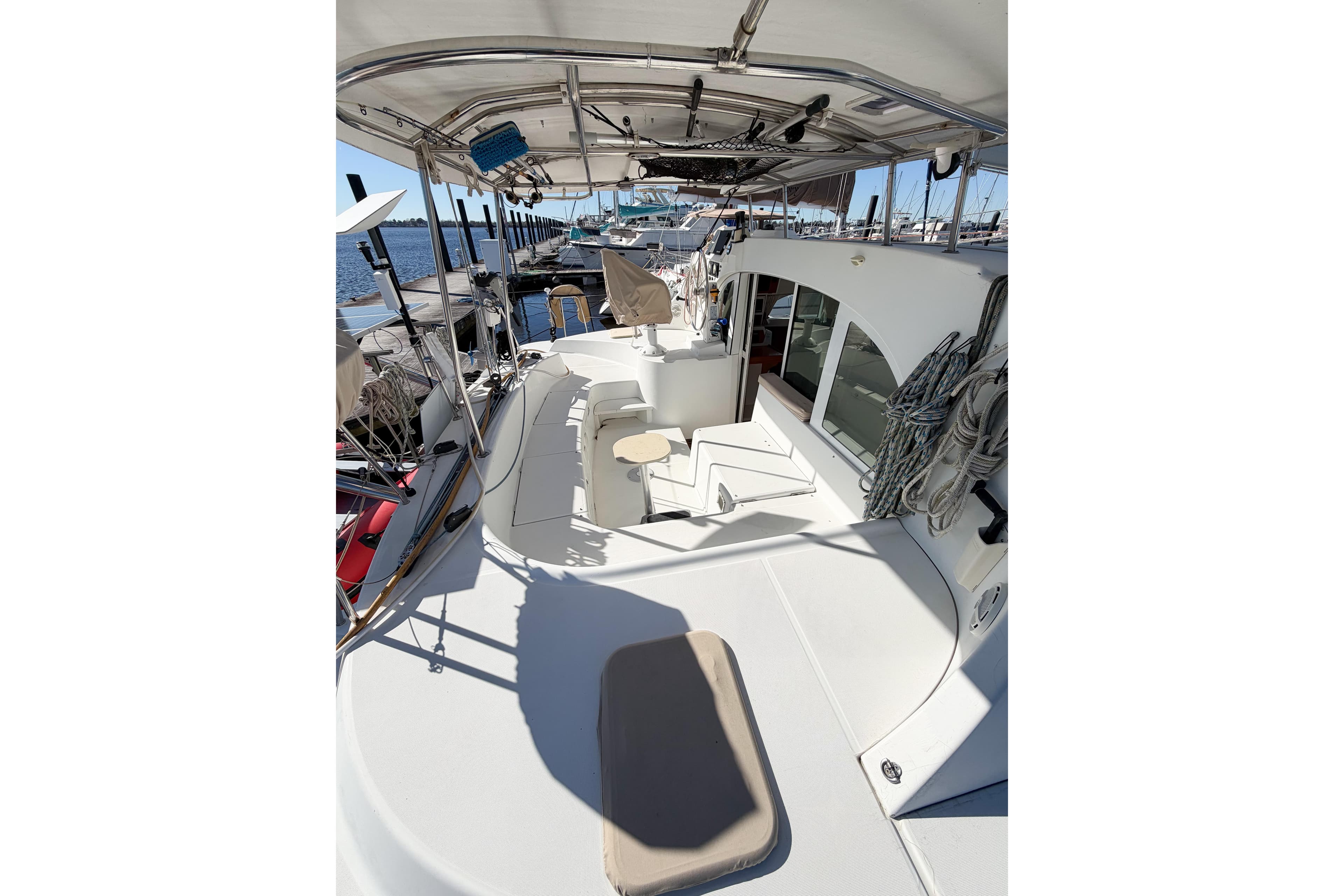 2005 Lagoon 380 S2 catamaran deck with seating and marina view.