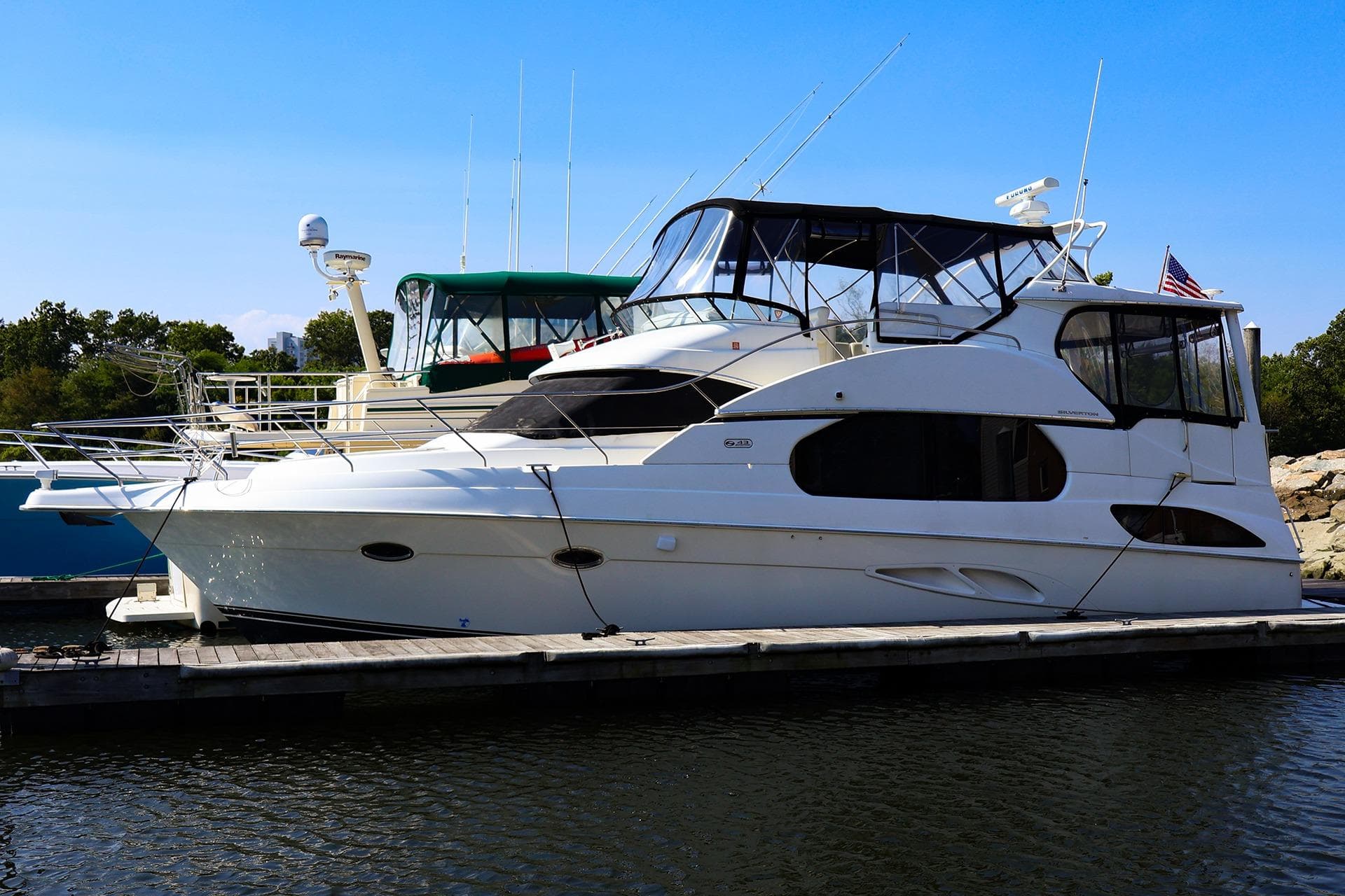 2002 Silverton 43 Motor Yacht docked at marina, clear sky background.