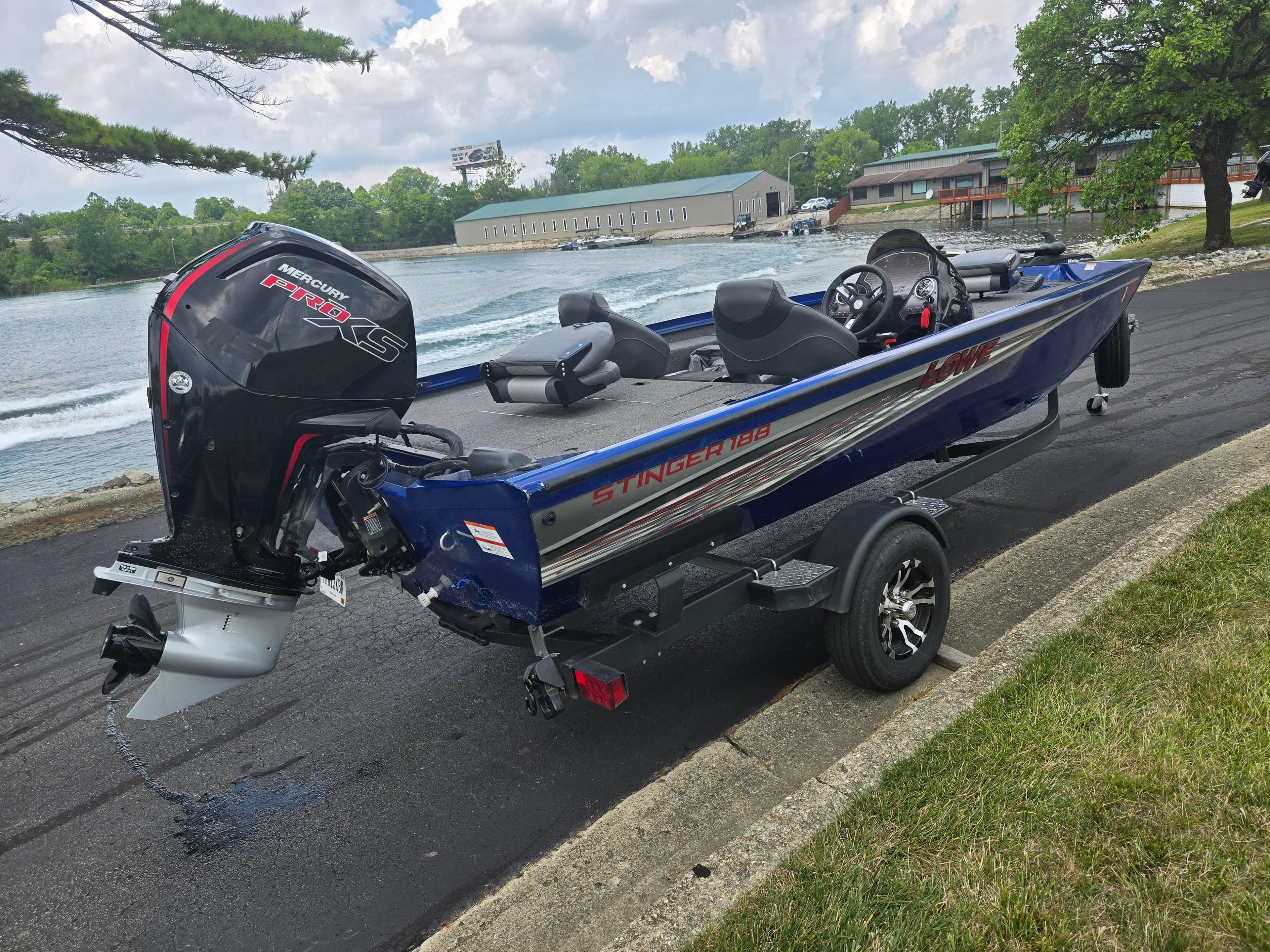 2021 Lowe Stinger 188 boat on trailer by lakeside, featuring Mercury Pro XS engine.