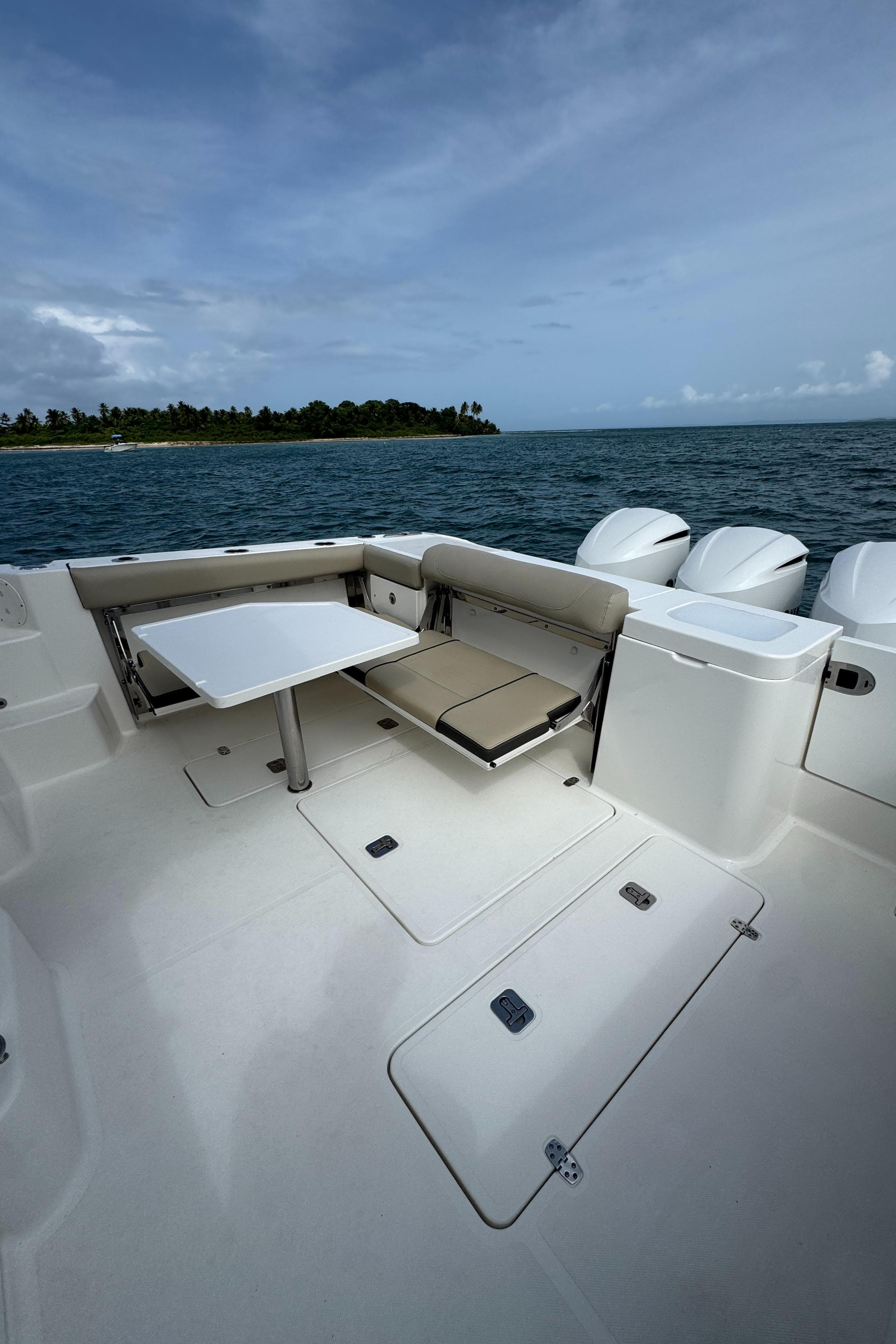 2019 Pursuit OS 355 Offshore boat deck with seating, table, and ocean view.
