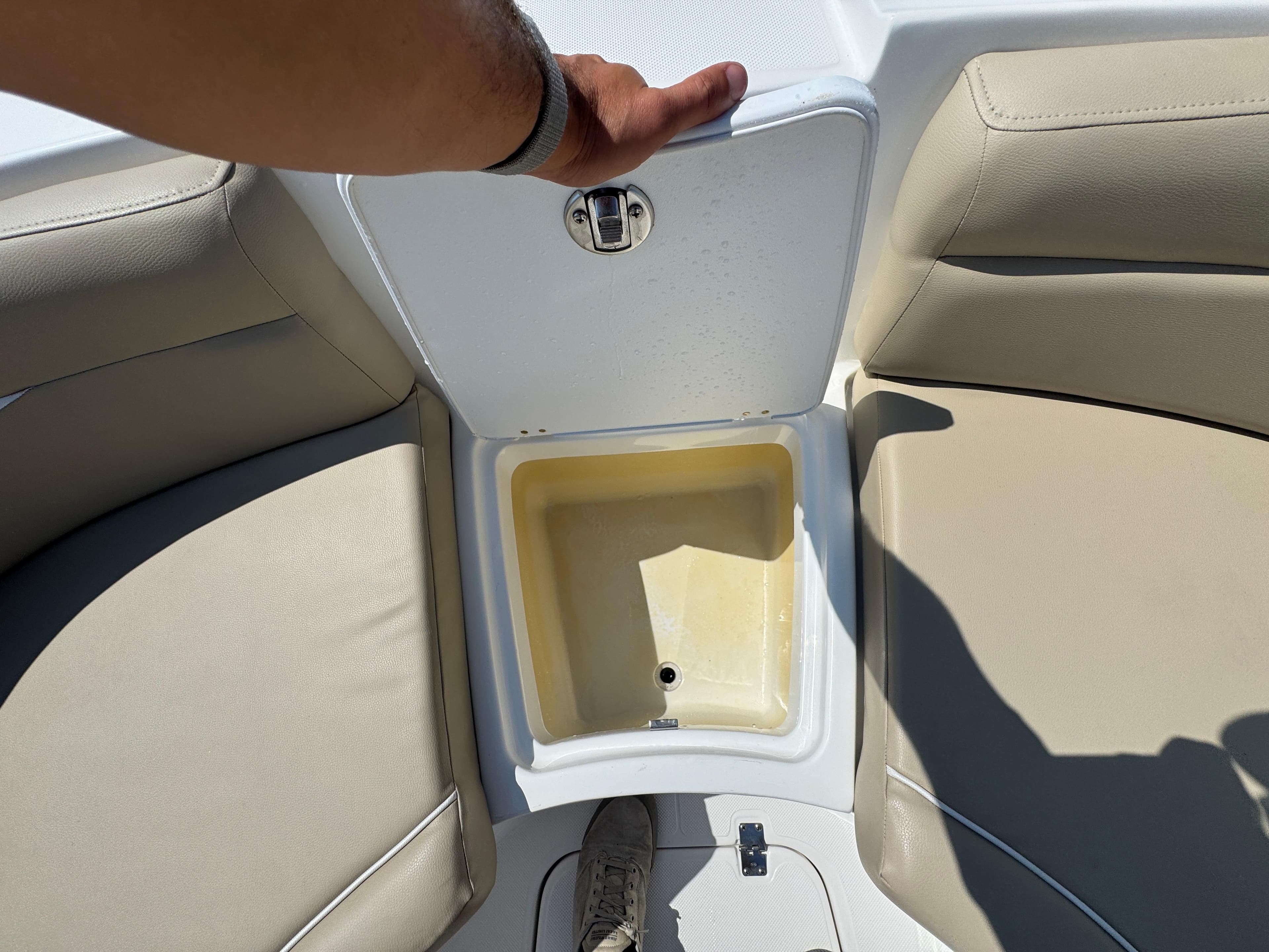 2017 Hurricane SunDeck Sport 203 OB boat storage compartment with beige seating.