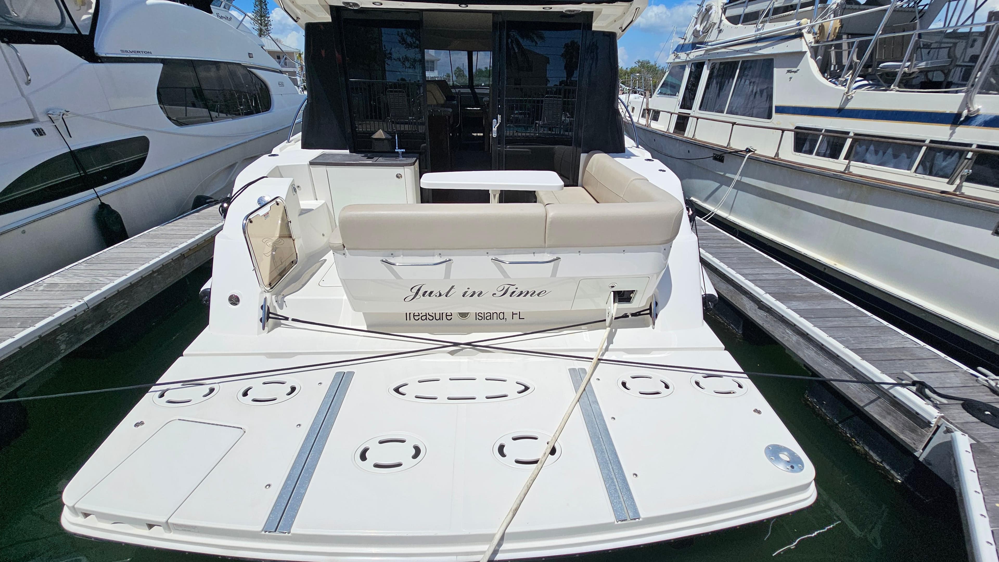 2016 Sea Ray 470 Sundancer yacht docked, rear view with seating and swim platform.