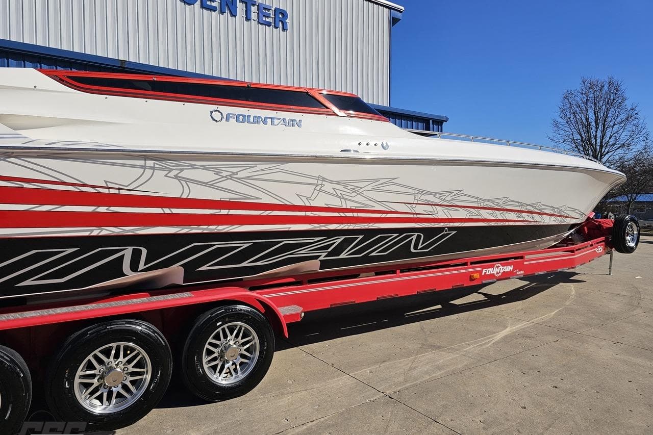 2009 Fountain 47 Lightning boat on red trailer, parked outside a building.
