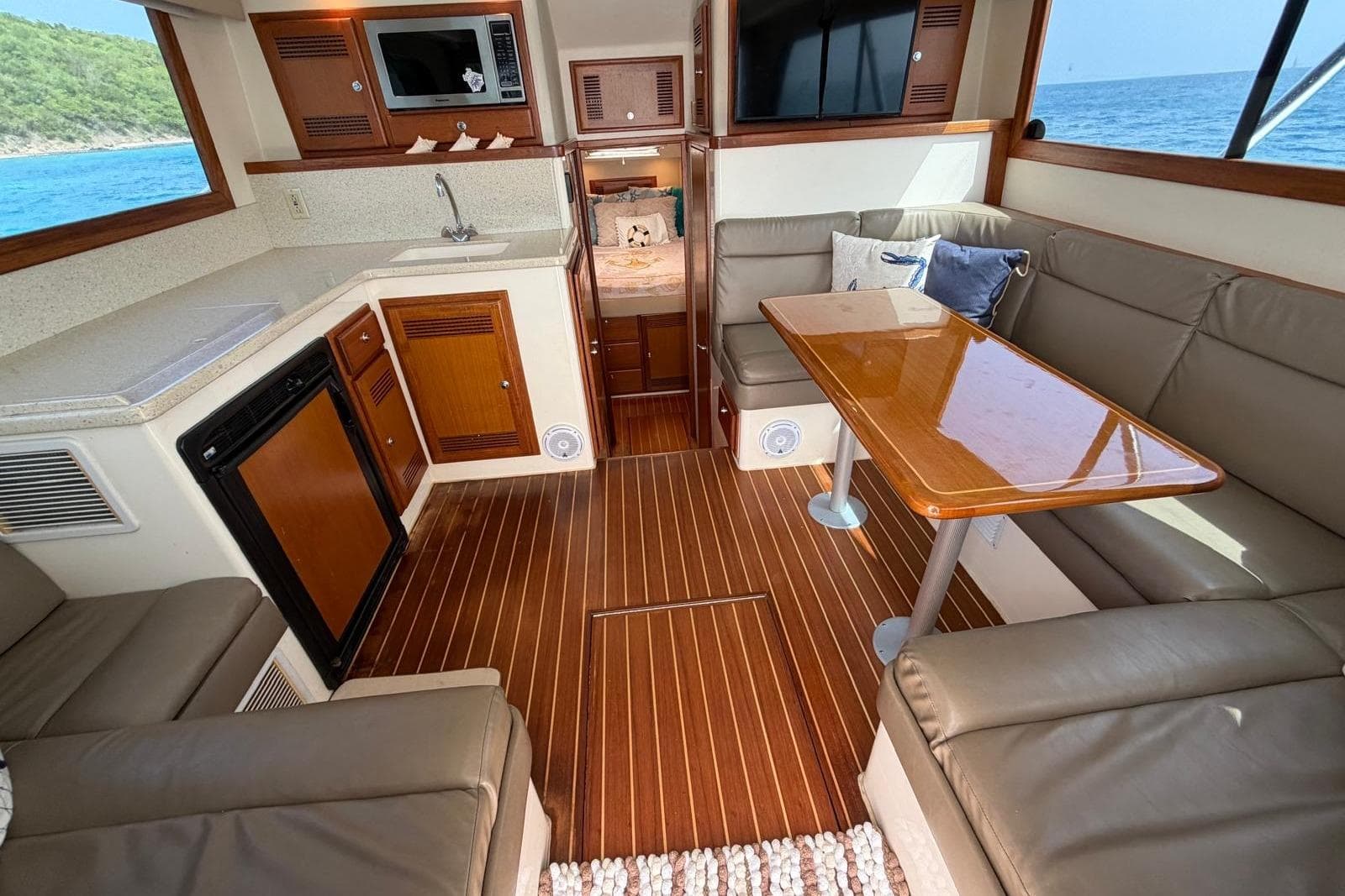Interior of 2004 Cabo 35 Flybridge yacht with kitchen and seating area, ocean view.