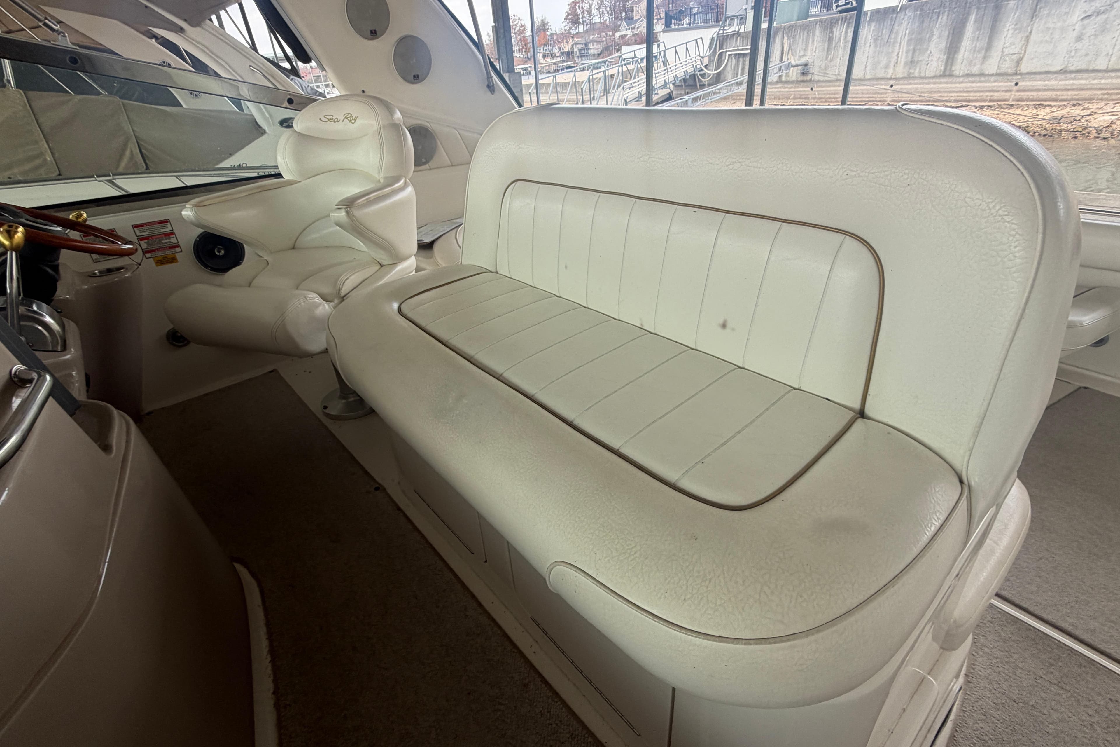 1999 Sea Ray 400 Sundancer interior with white leather seating and helm chair.