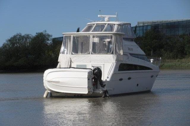 2008 Carver 47 Motor Yacht on calm water, rear view with tender attached.