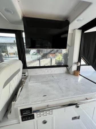 Interior of 2023 Regal 36 XO yacht with TV and countertop.