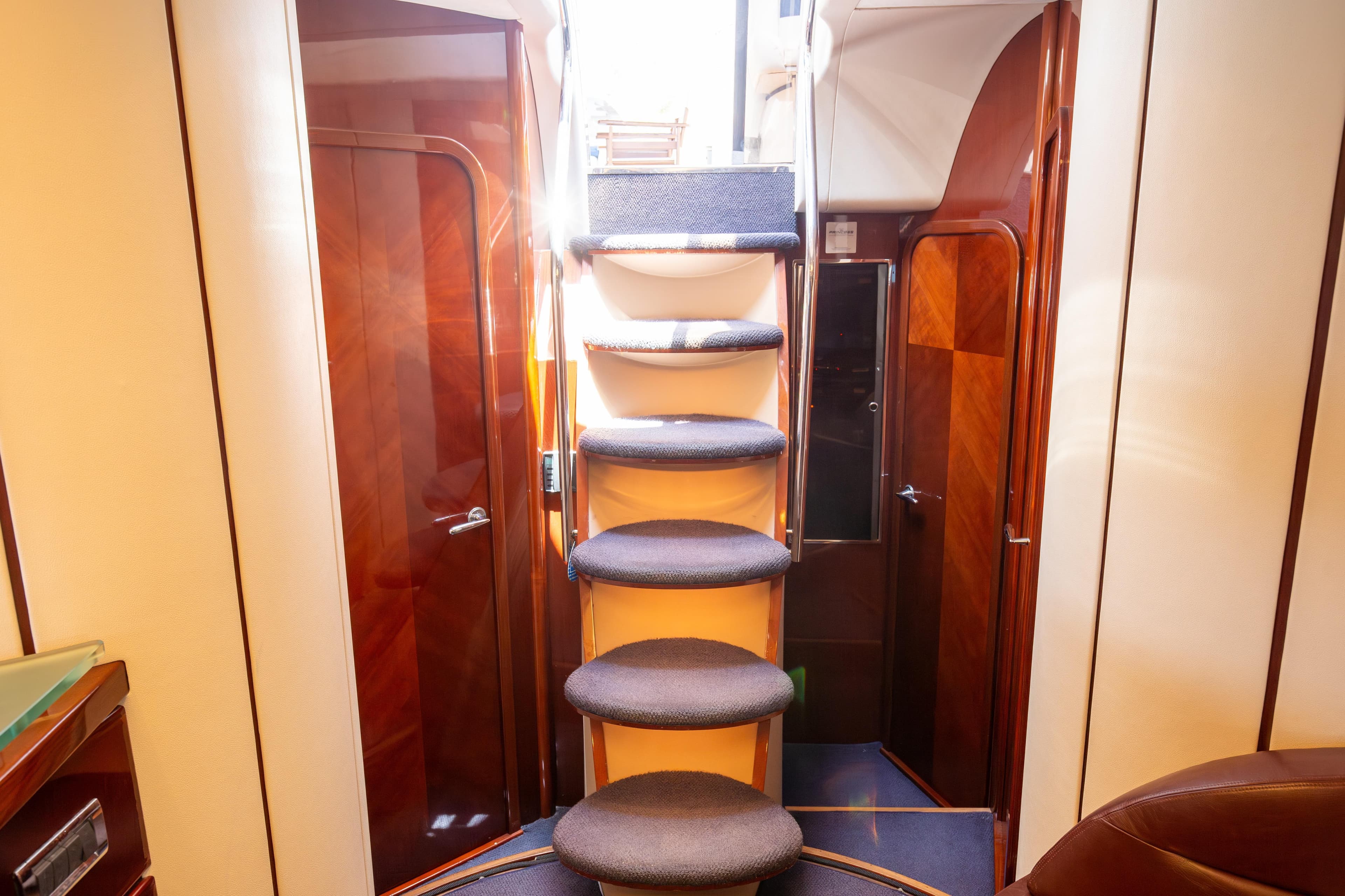Interior of 2004 Princess V65 yacht with elegant wooden stairs and doors.