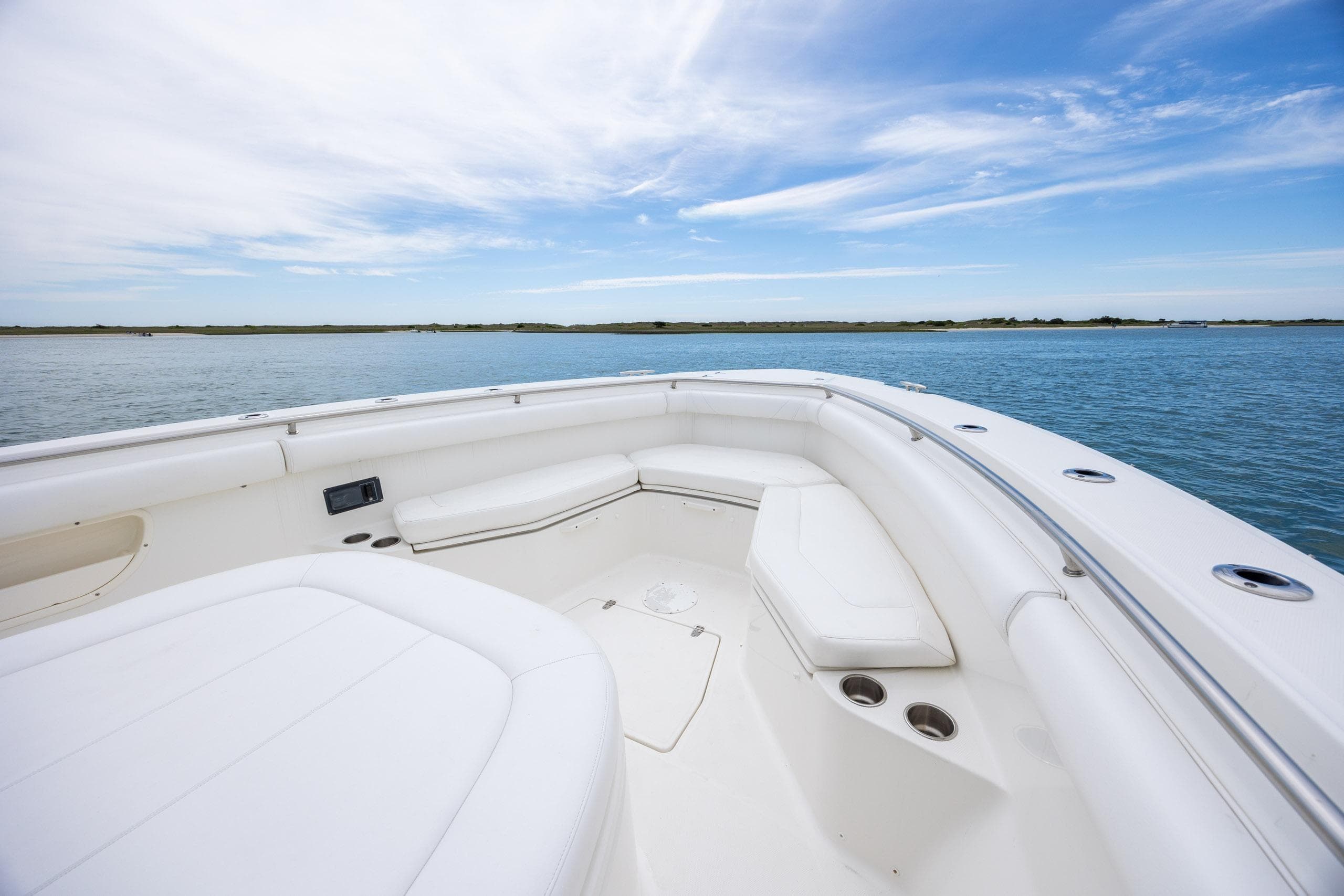 2017 Boston Whaler 370 Outrage boat interior with white seating, on calm water.