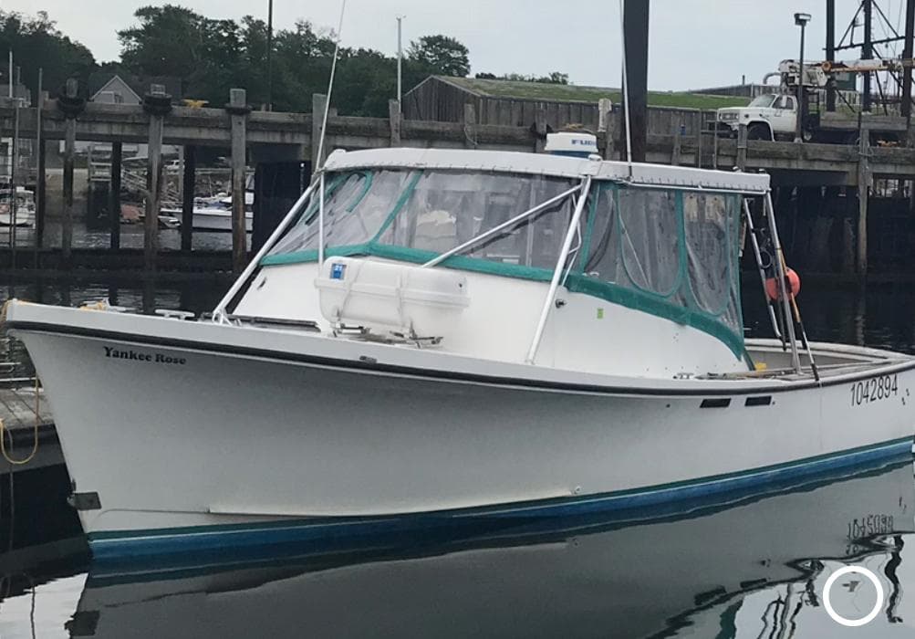 1988 JC Provincetown boat docked at marina with green canopy.
