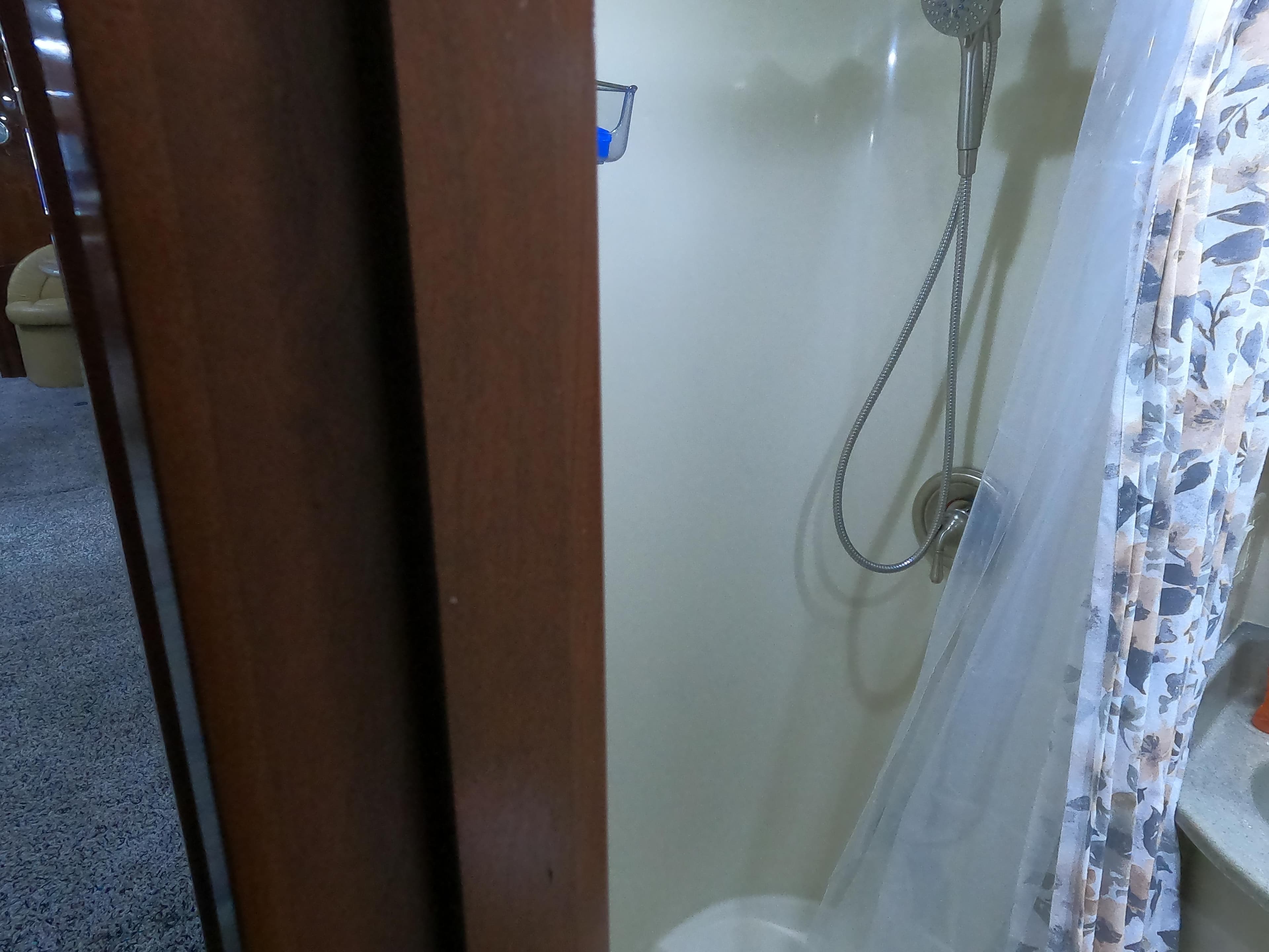 Shower area inside 2006 Bluewater Yachts 5200, featuring a handheld showerhead and curtain.