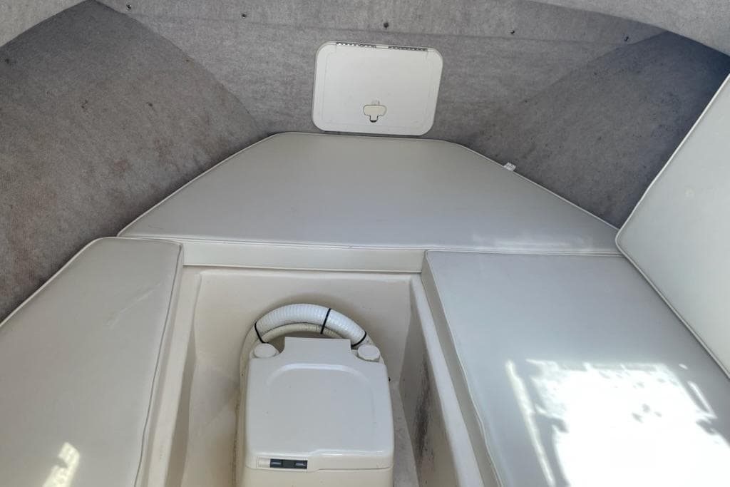 2008 Parker 2310 Walkaround cabin interior with compact toilet and cushioned seating.