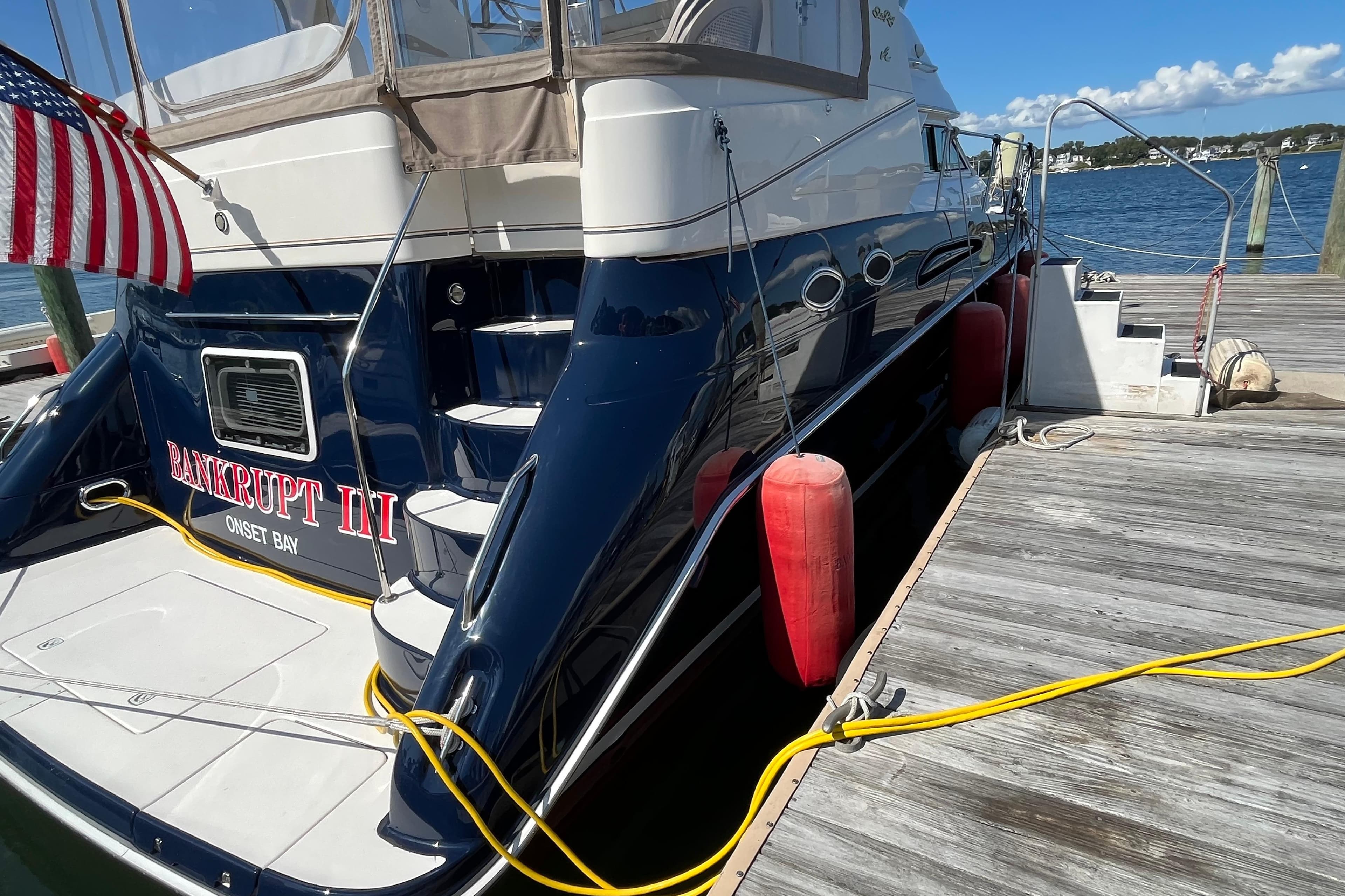1997 Sea Ray 420 Aft Cabin yacht docked with American flag and red fenders.